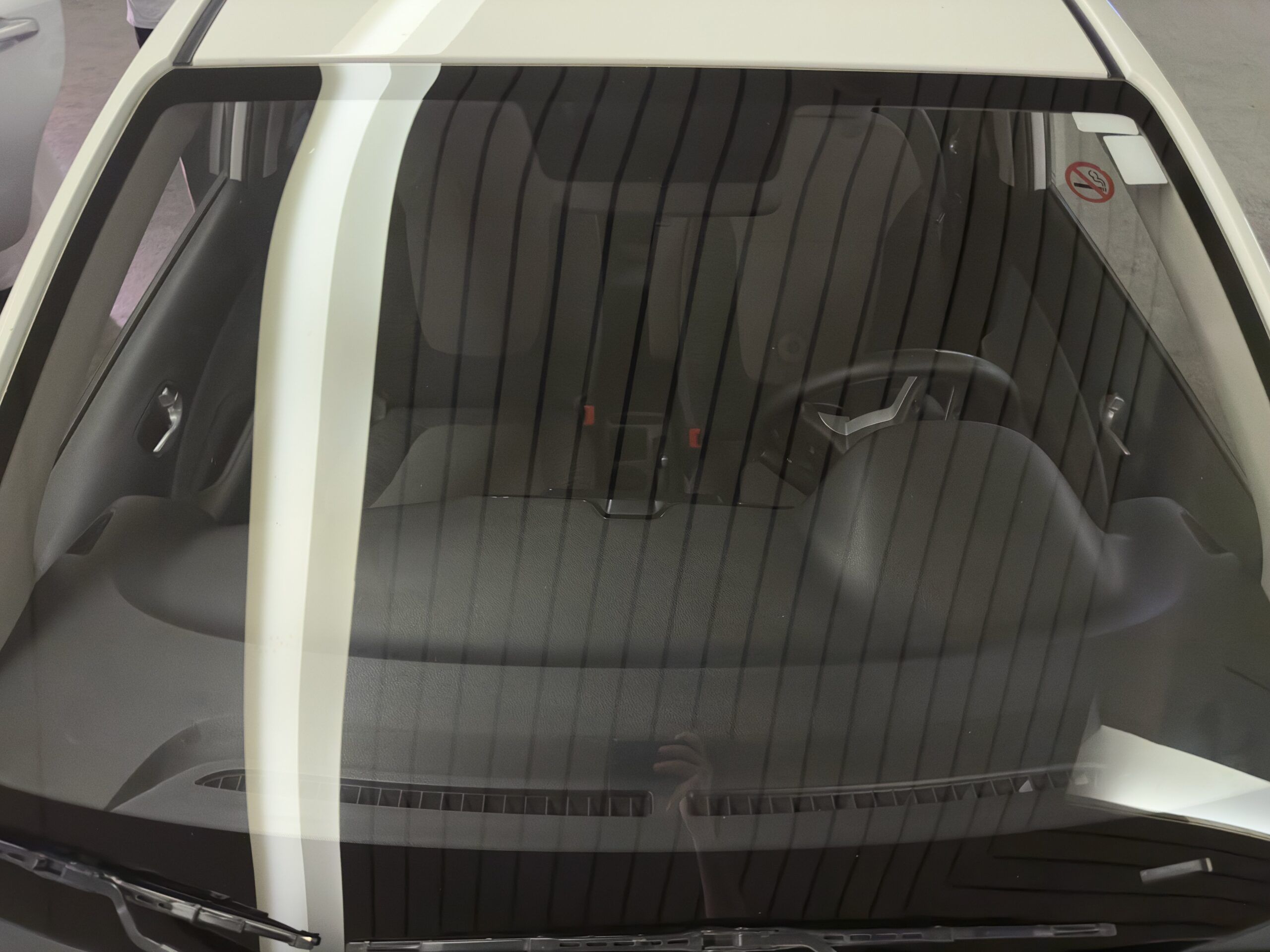 Front view of a parked car in saudi arabia, seen through a windshield with reflections.