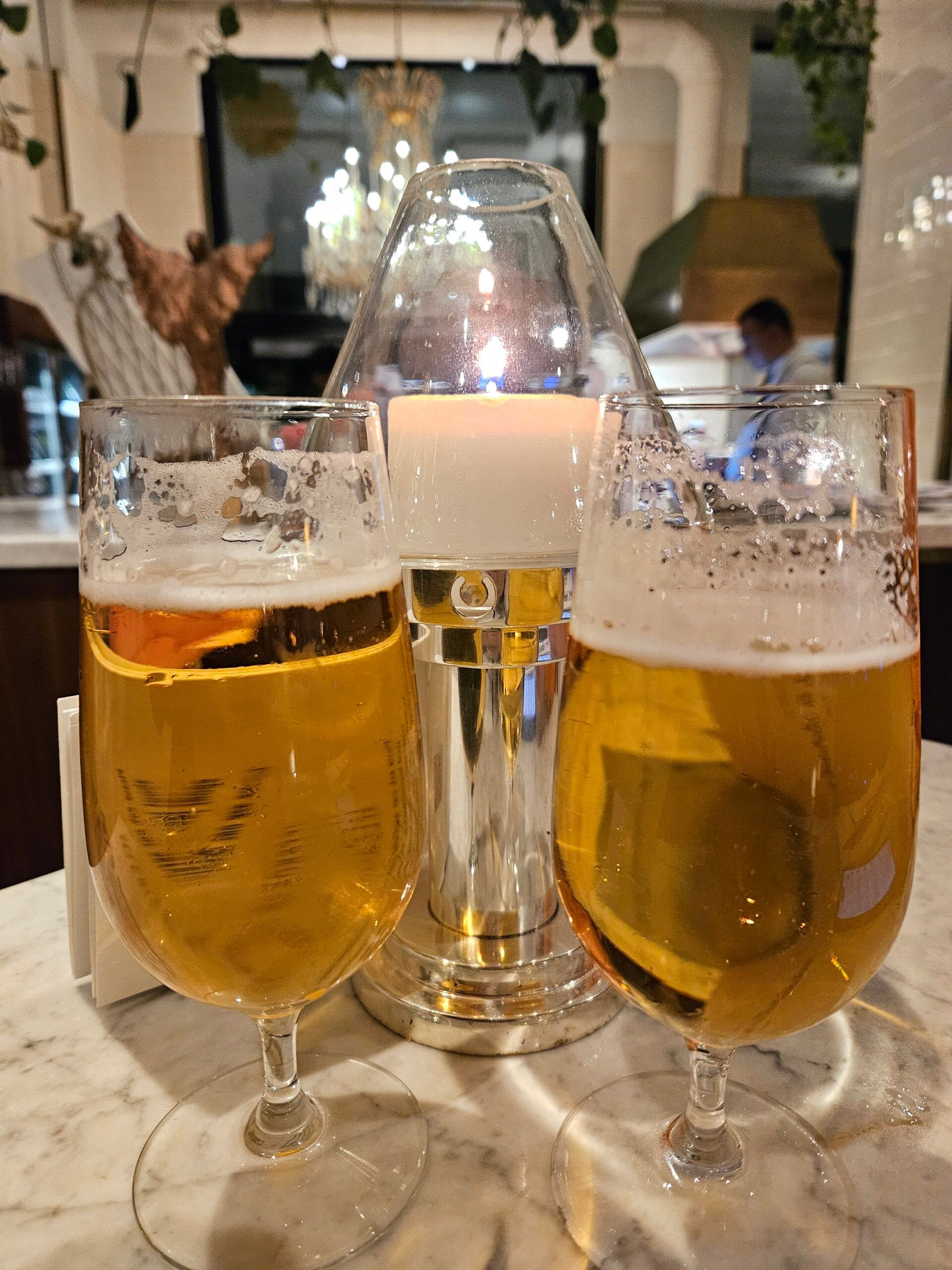 Dwa kieliszki piwa i świeca na stole w restauracji w wiedniu, austria
