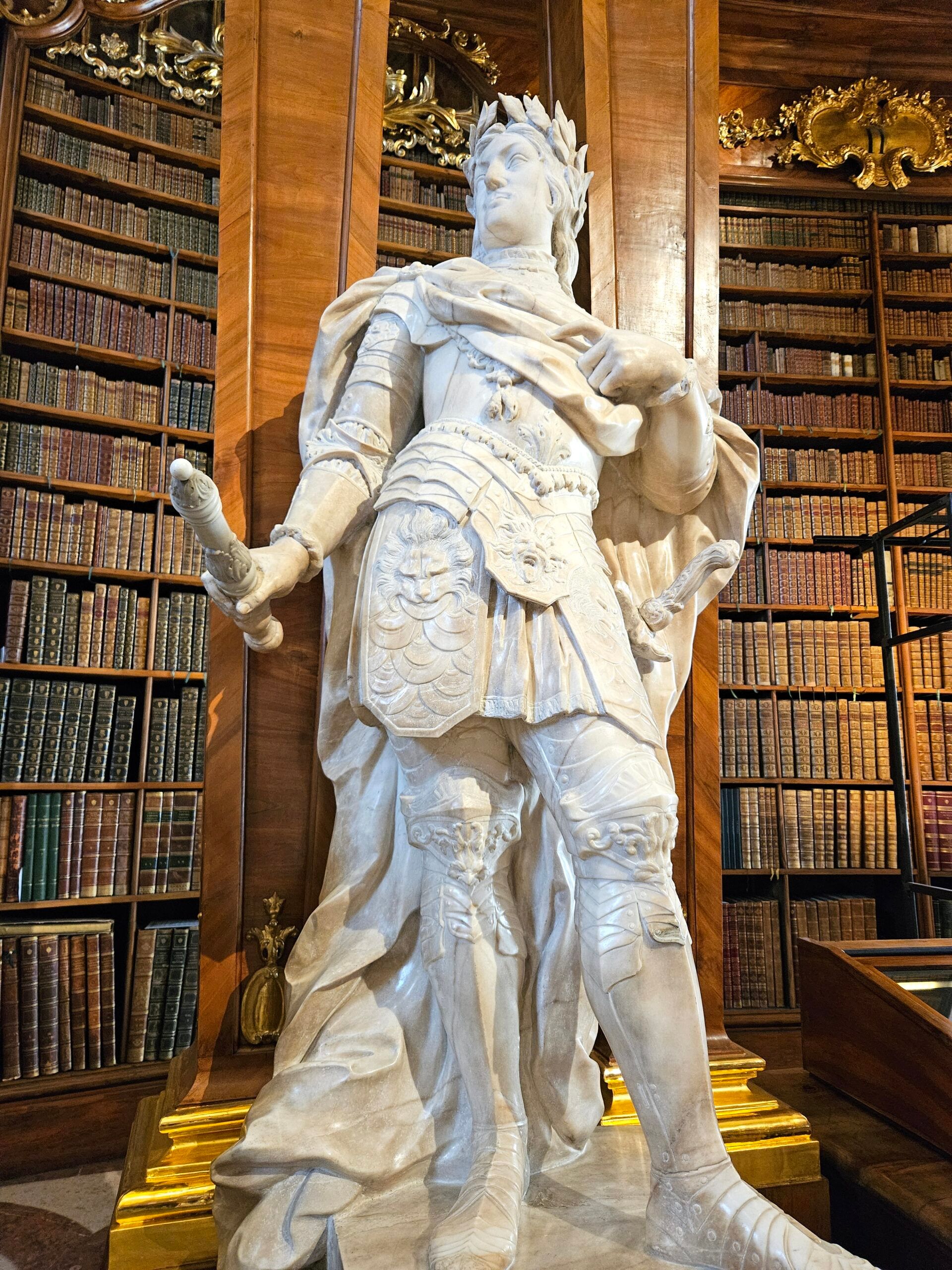 Rzeźba w austriackiej bibliotece narodowej w wiedniu, otoczona regałami z książkami