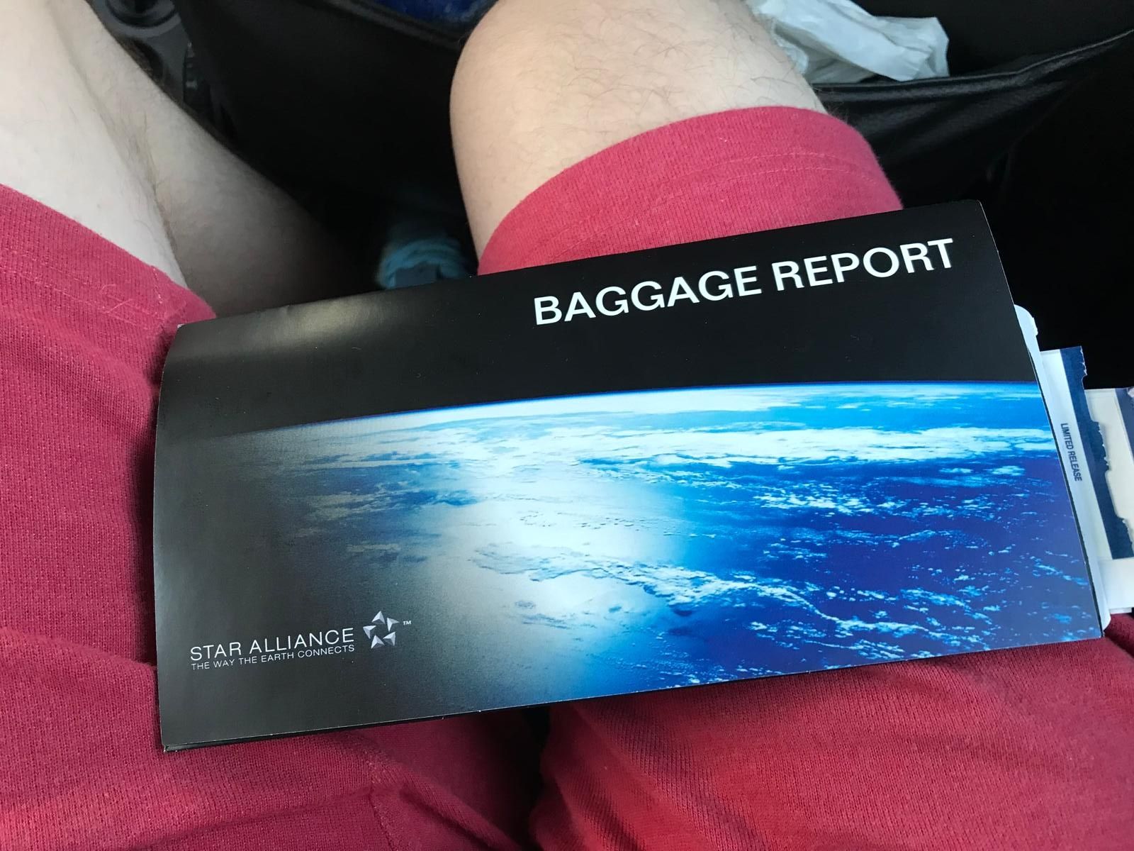 Raport o bagażu star alliance trzymany na kolanach w samolocie.