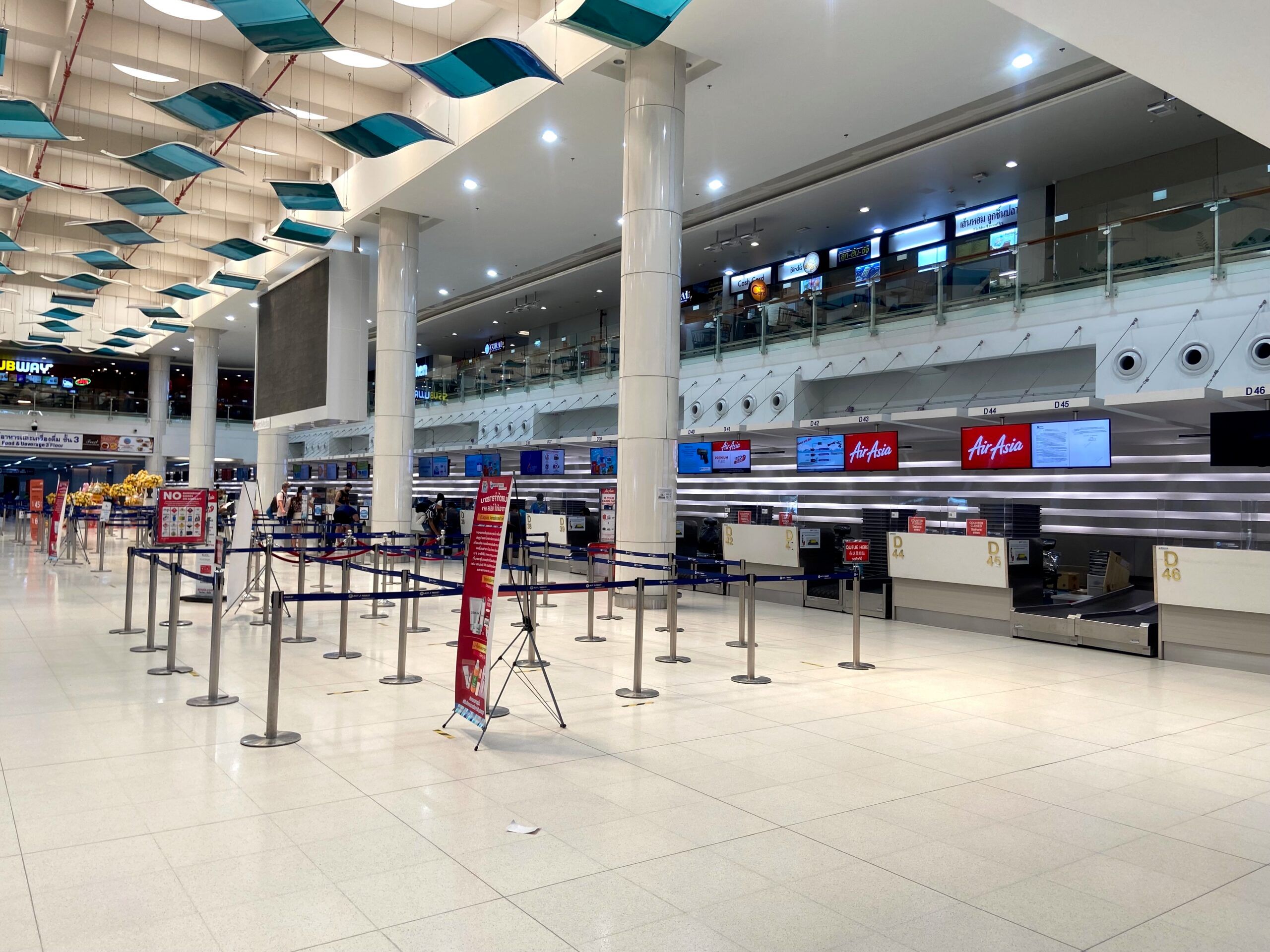 Pusta hala odpraw na lotnisku w tajlandii z pustymi stanowiskami airasia i taśmami