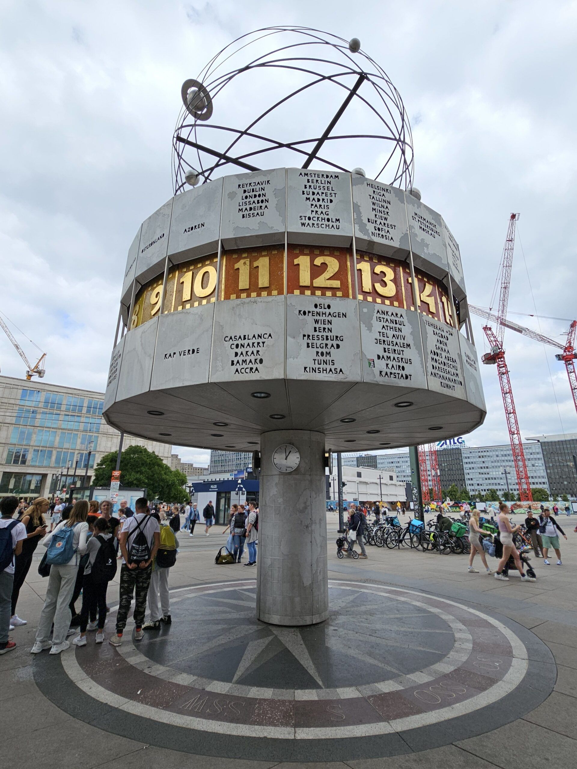 Zegar świata na alexanderplatz w berlinie, z nazwami miast i ludźmi na placu