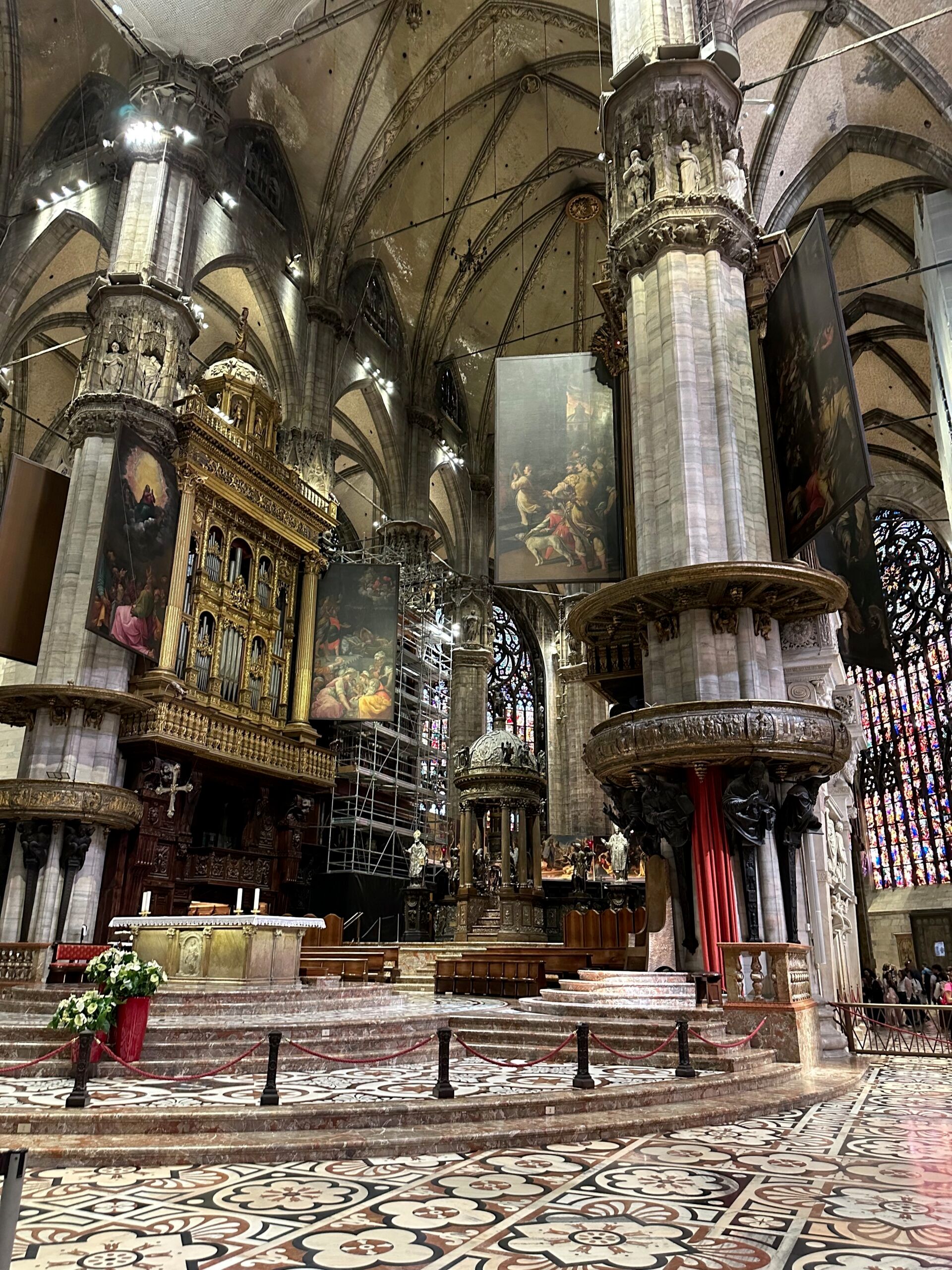 Wnętrze katedry duomo w mediolanie z monumentalnymi kolumnami, ołtarzem i witrażami