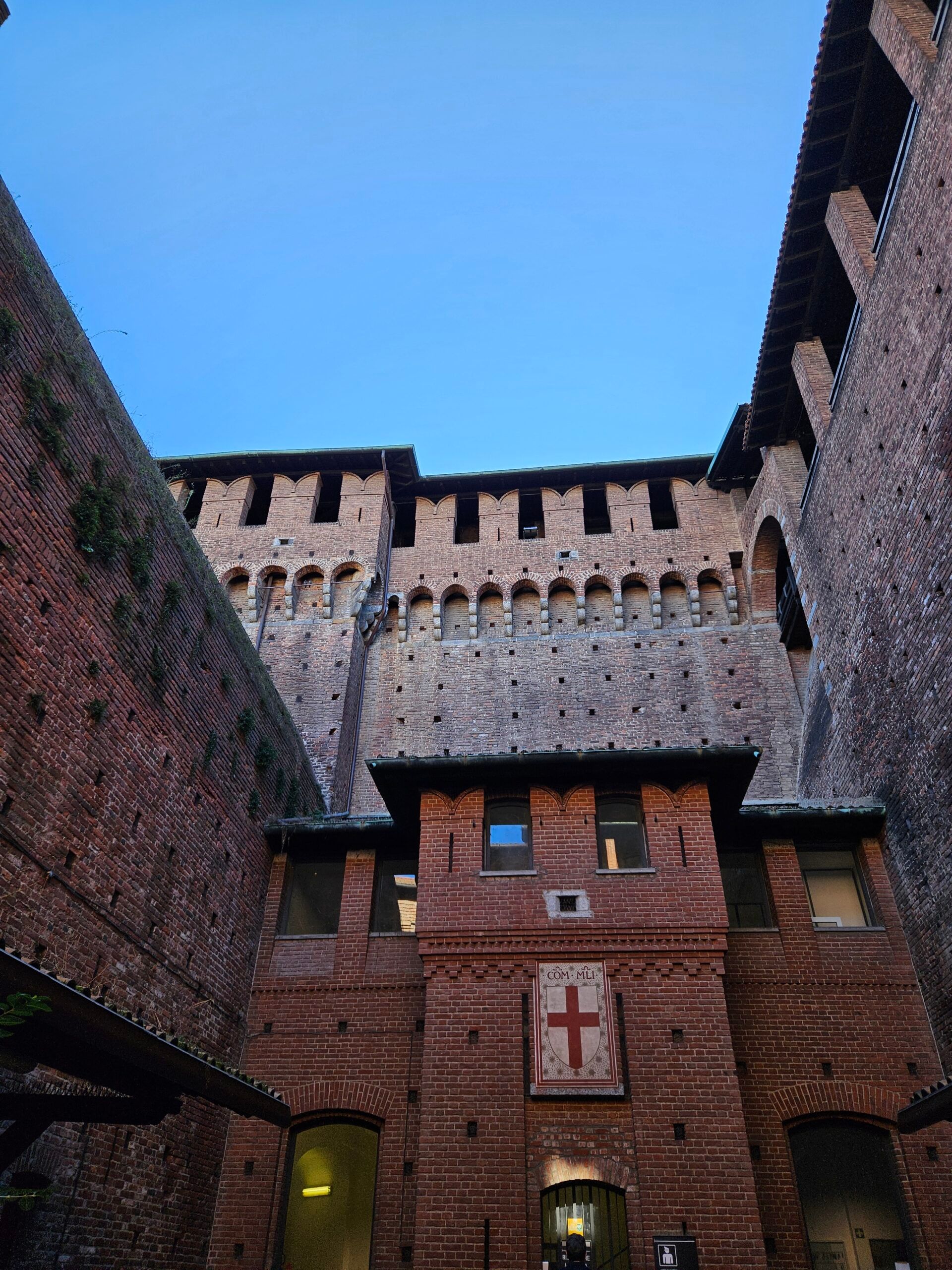 Dziedziniec milano castle z ceglanymi murami i wieżami pod błękitnym niebem
