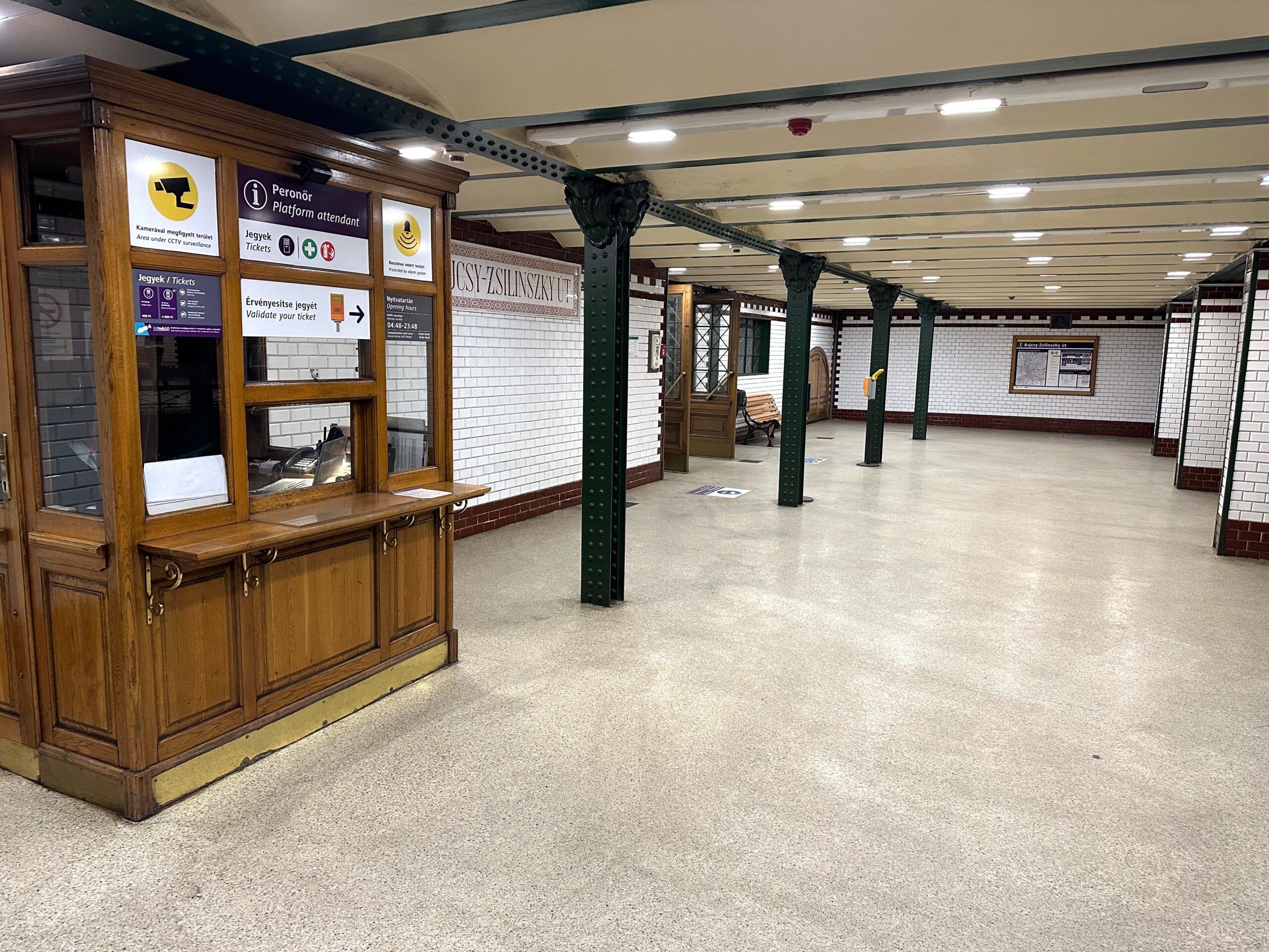 Pusty peron stacji metra budapest z drewnianą kasą biletową i zielonymi kolumnami