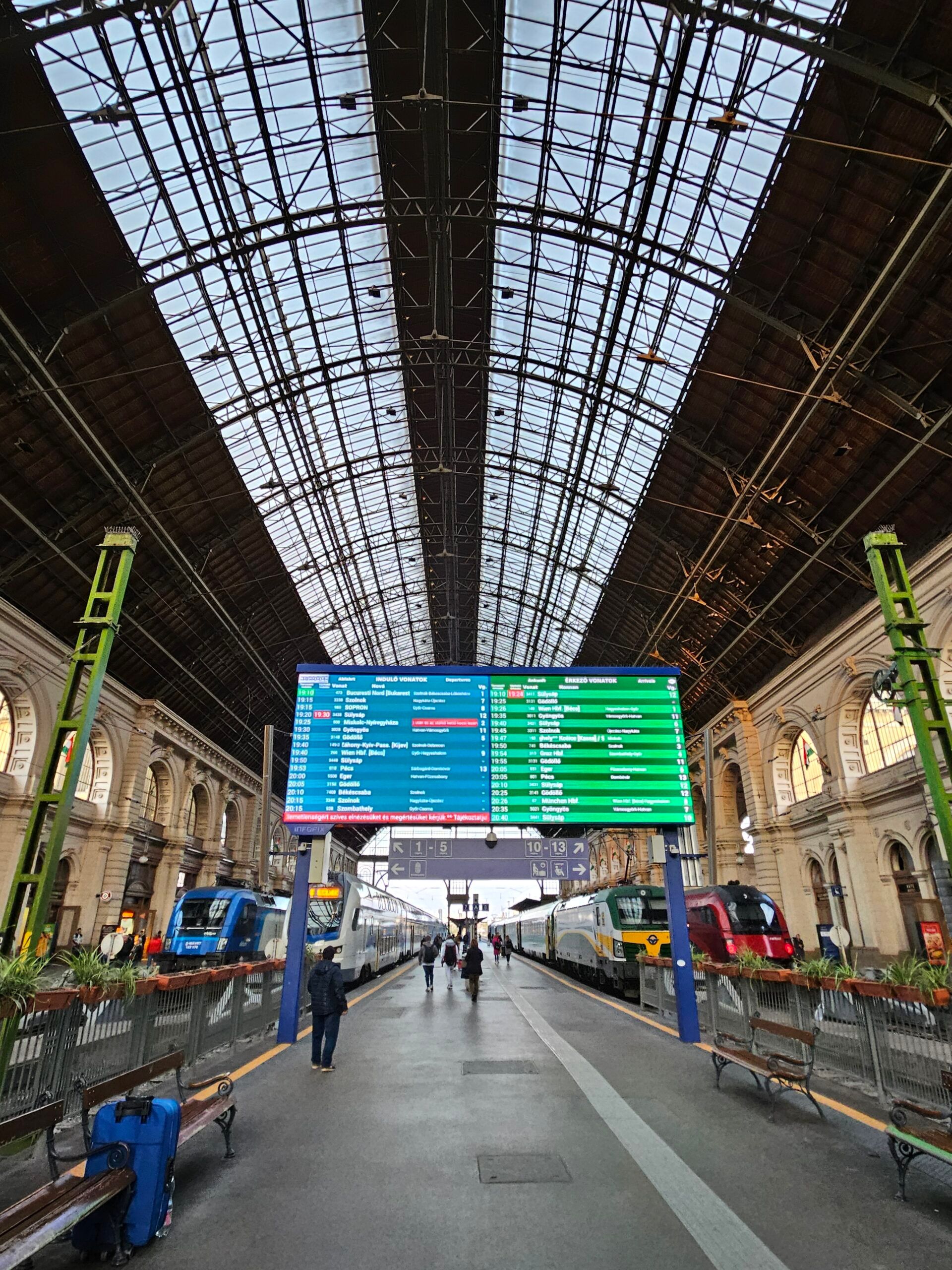 Dworzec budapest main train station z tablicami odjazdów i pociągami pod wysokim szklanym dachem