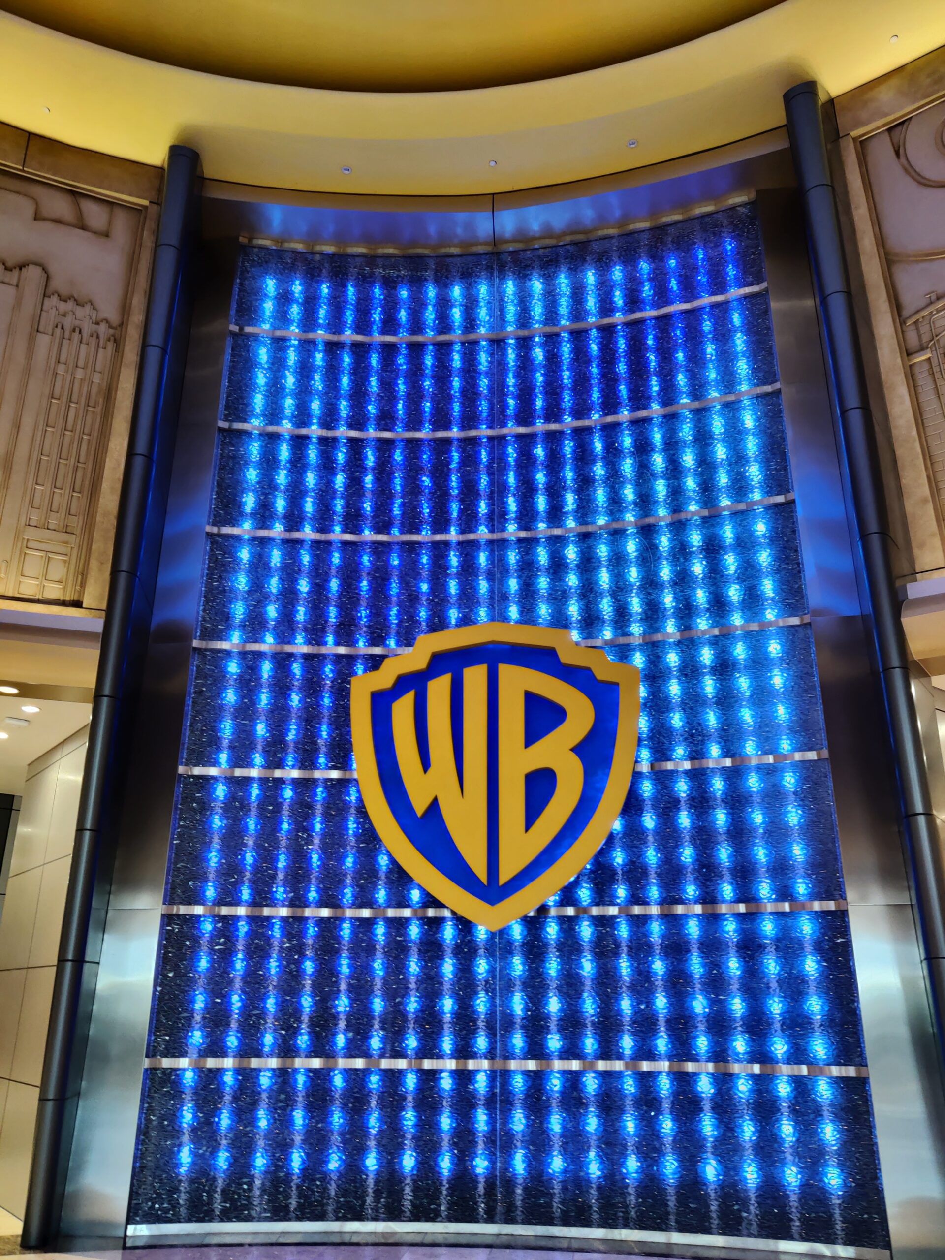 Logo warner bros w abu dhabi, na podświetlanej niebieskiej ścianie w hali.