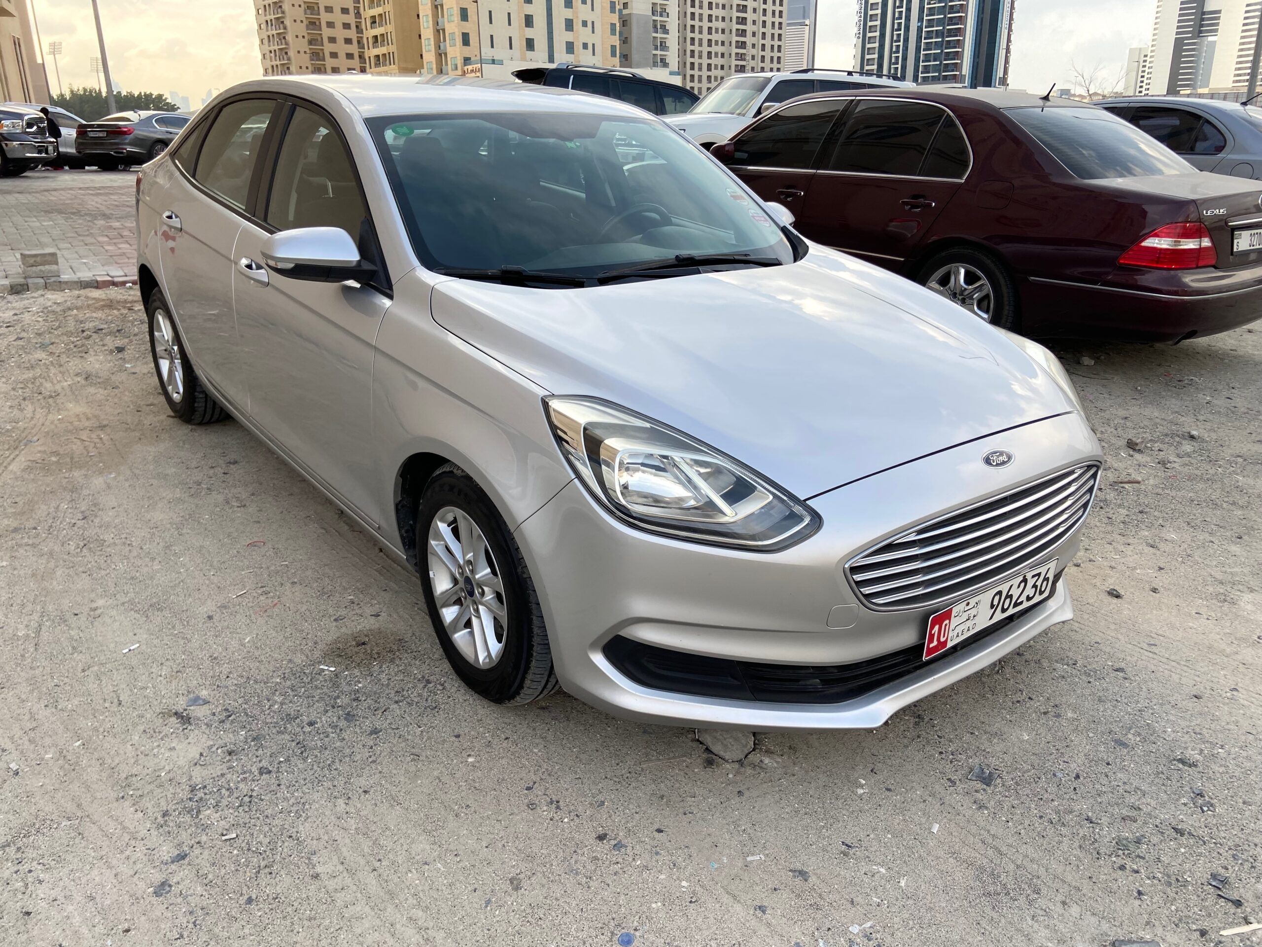 Wynajem samochodu w dubaju, srebrny sedan ford na parkingu