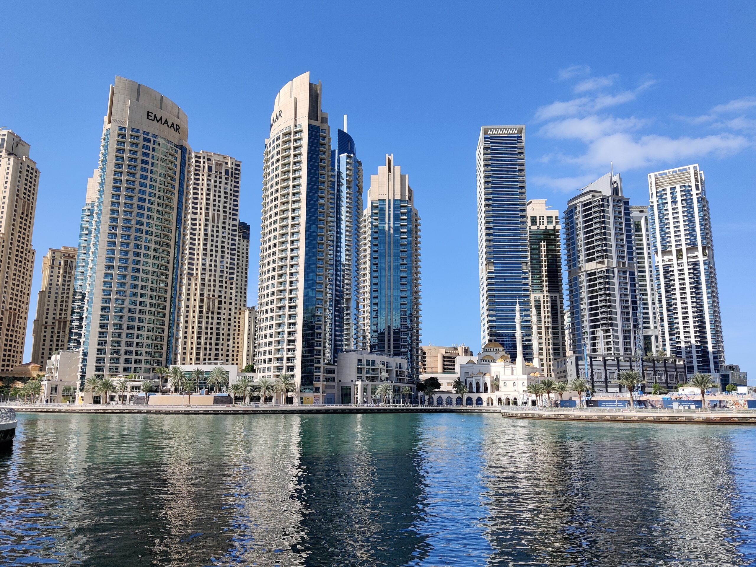 Dubai marina z wieżowcami nad wodą i odbiciami w marinie