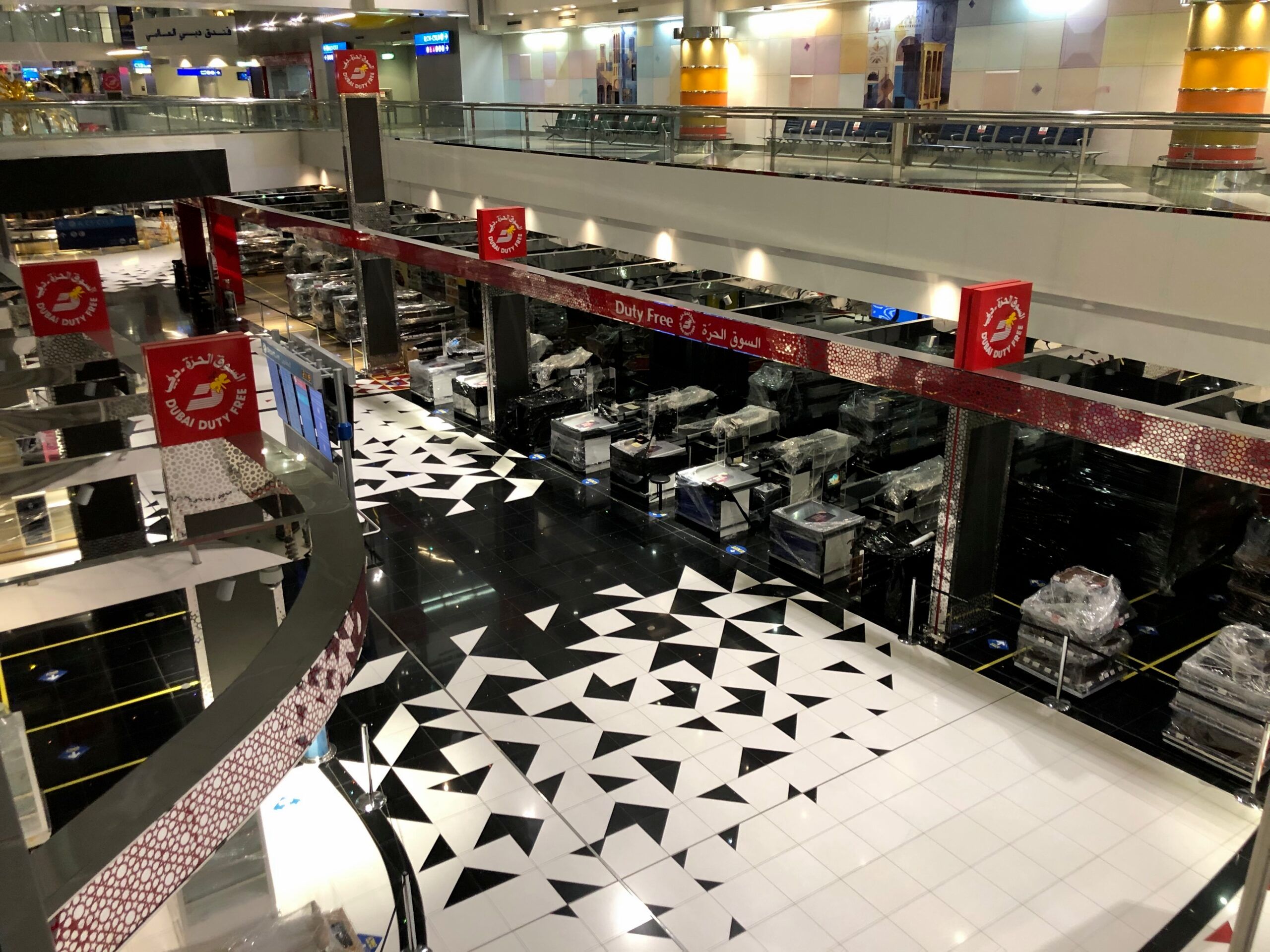 Strefa duty free na lotnisku w dubaju z czarno-białą podłogą i zamkniętymi stanowiskami