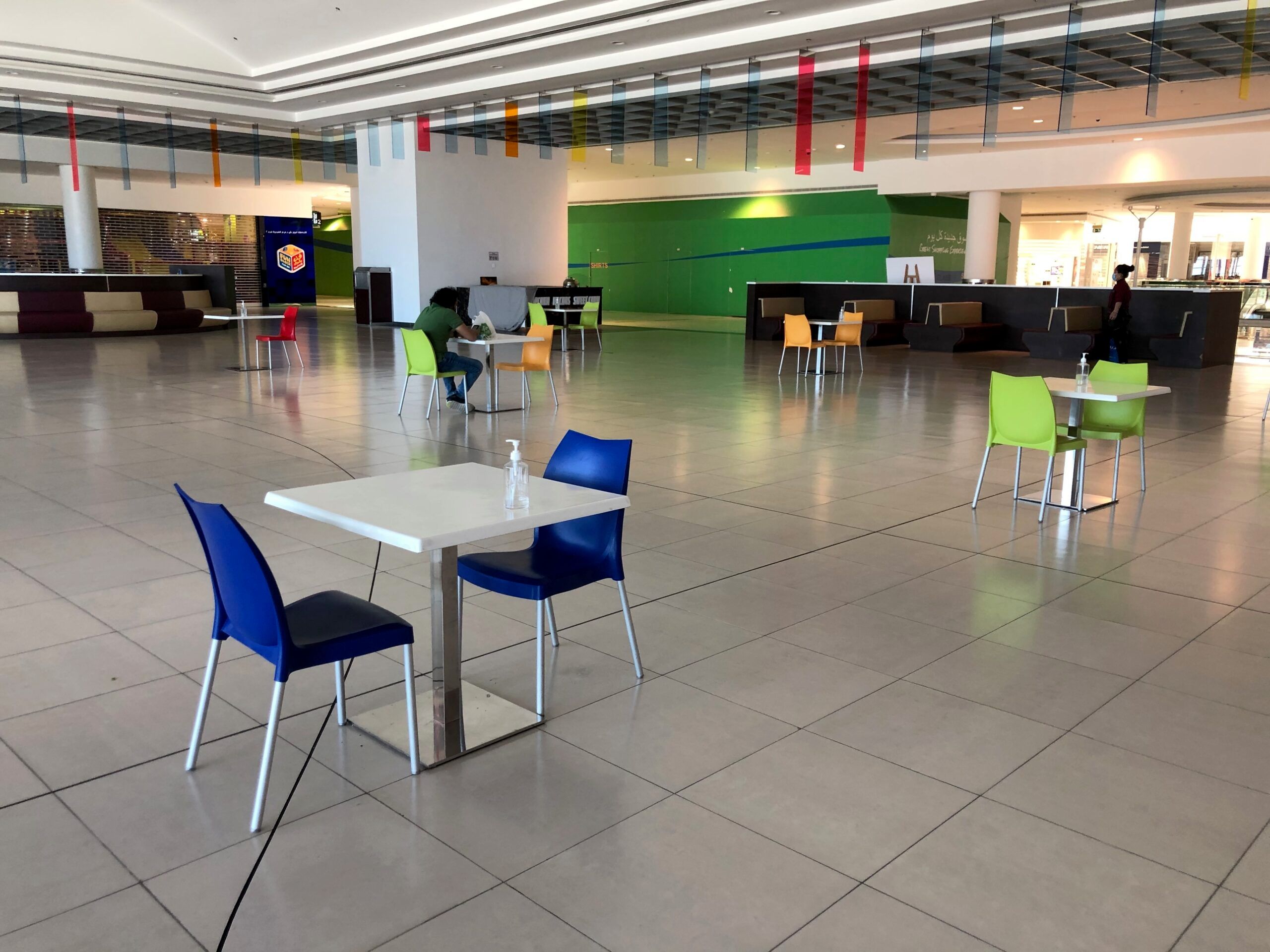 Pusta strefa wypoczynkowa w centrum handlowym fujairah w zea, z kolorowymi stolikami i krzesłami