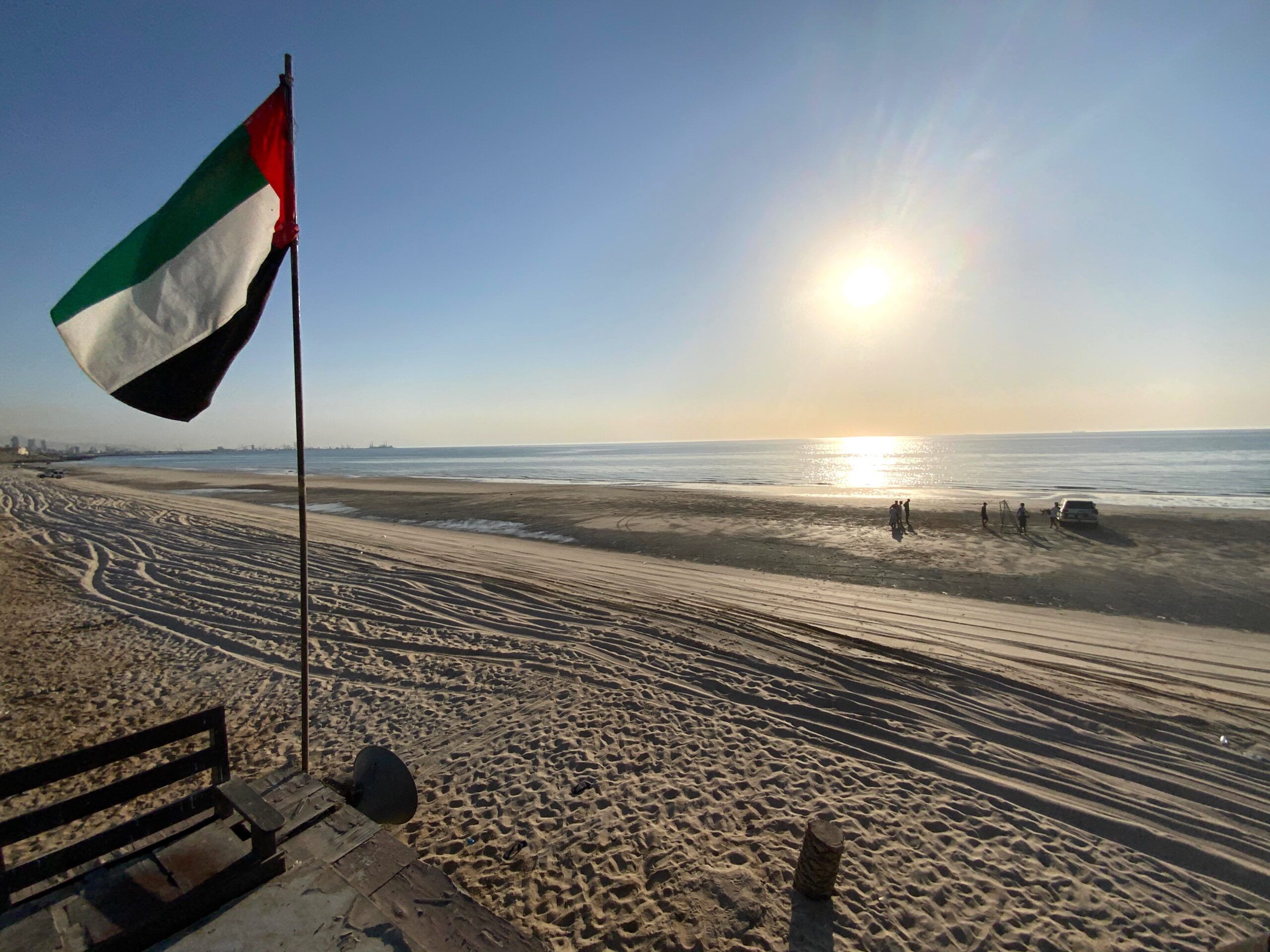 Plaża w ras al khaimah z flagą zea o zachodzie słońca