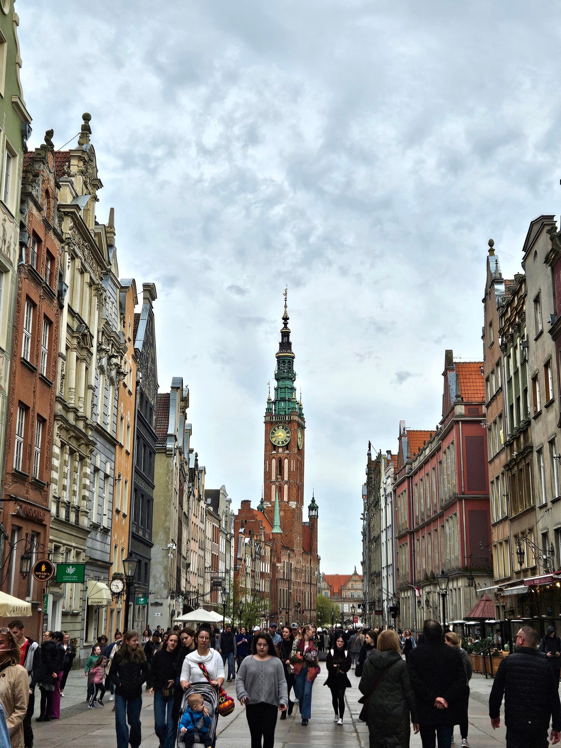 Ulica długa w gdańsku z wieżą ratusza głównego miasta i spacerującymi ludźmi