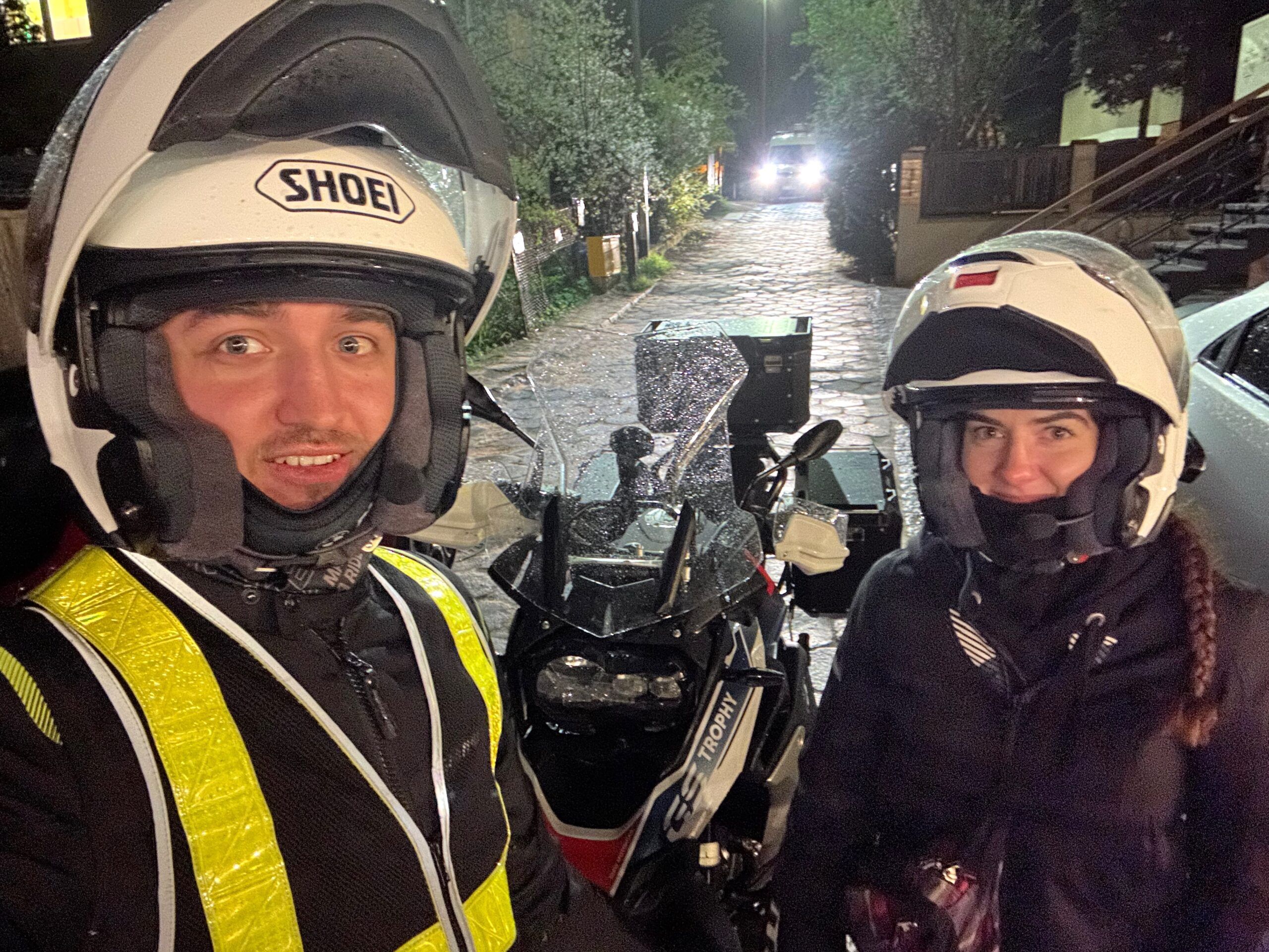 Dwoje motocyklistów w kaskach przy motocyklu gs trophy w gdańsku nocą.
