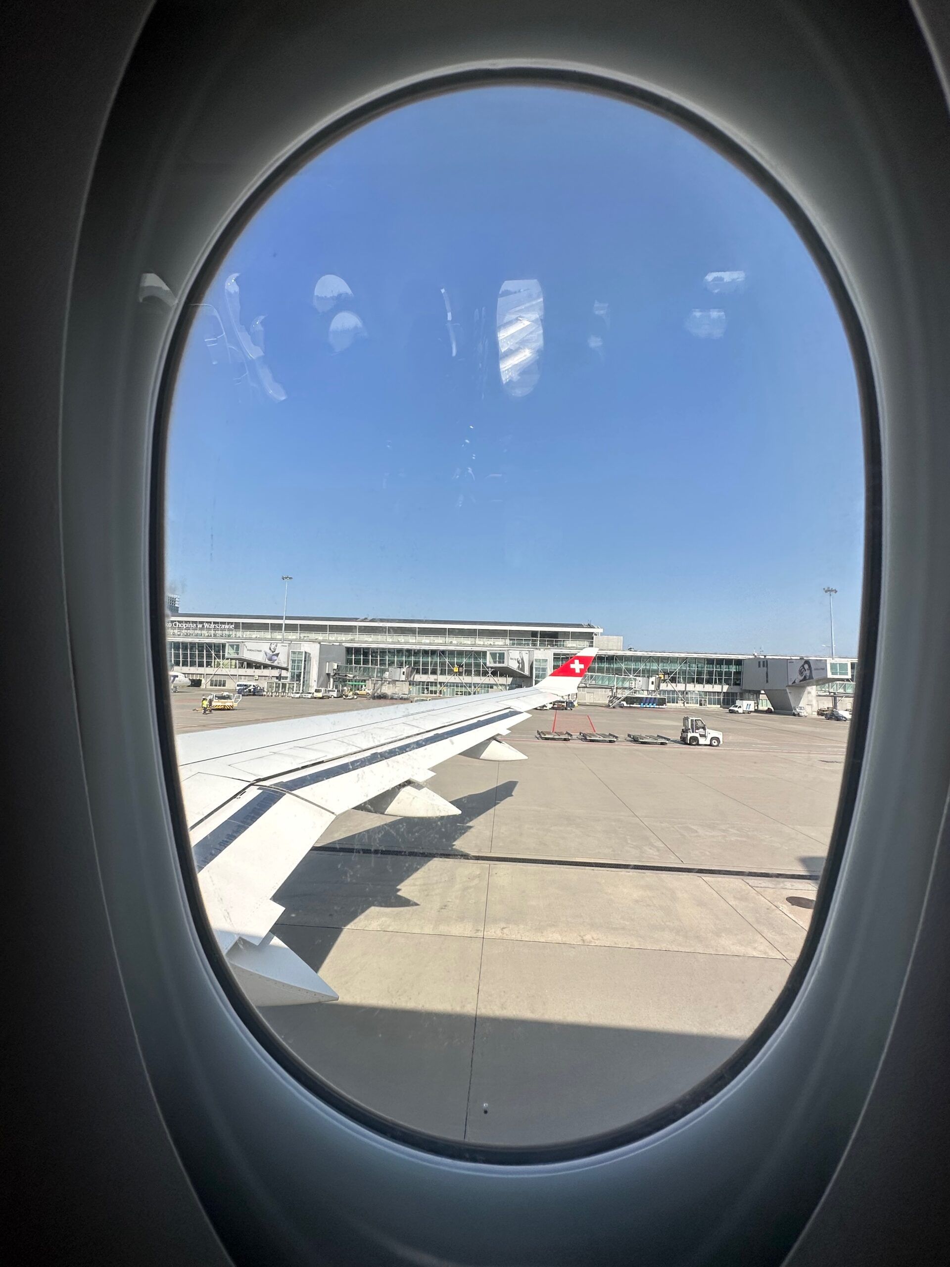 Widok z okna samolotu na płytę lotniska warszawa chopina i terminal.