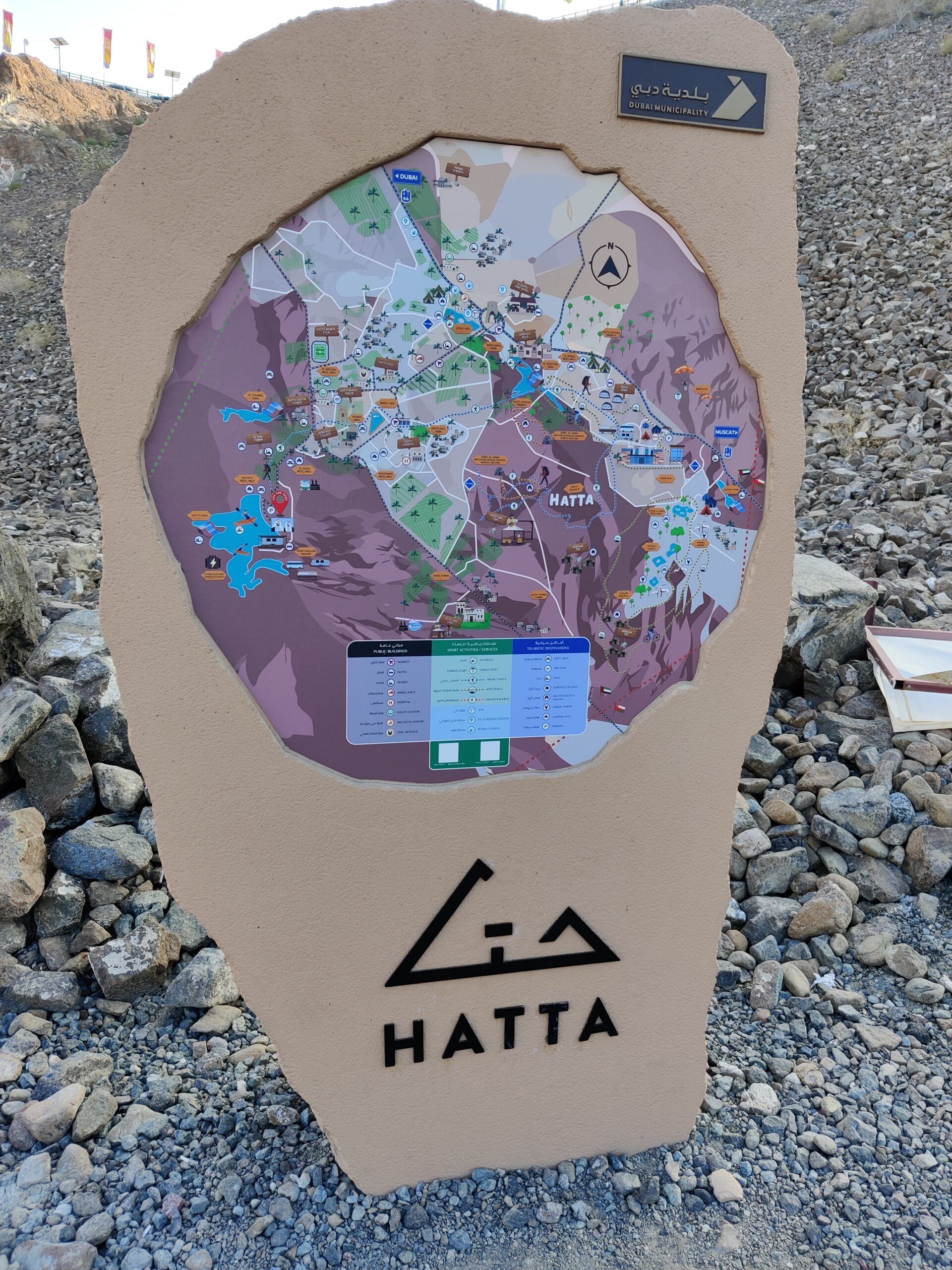 Tablica z mapą hatta w zjednoczonych emiratach arabskich, z logo hatta i dubai municipality.
