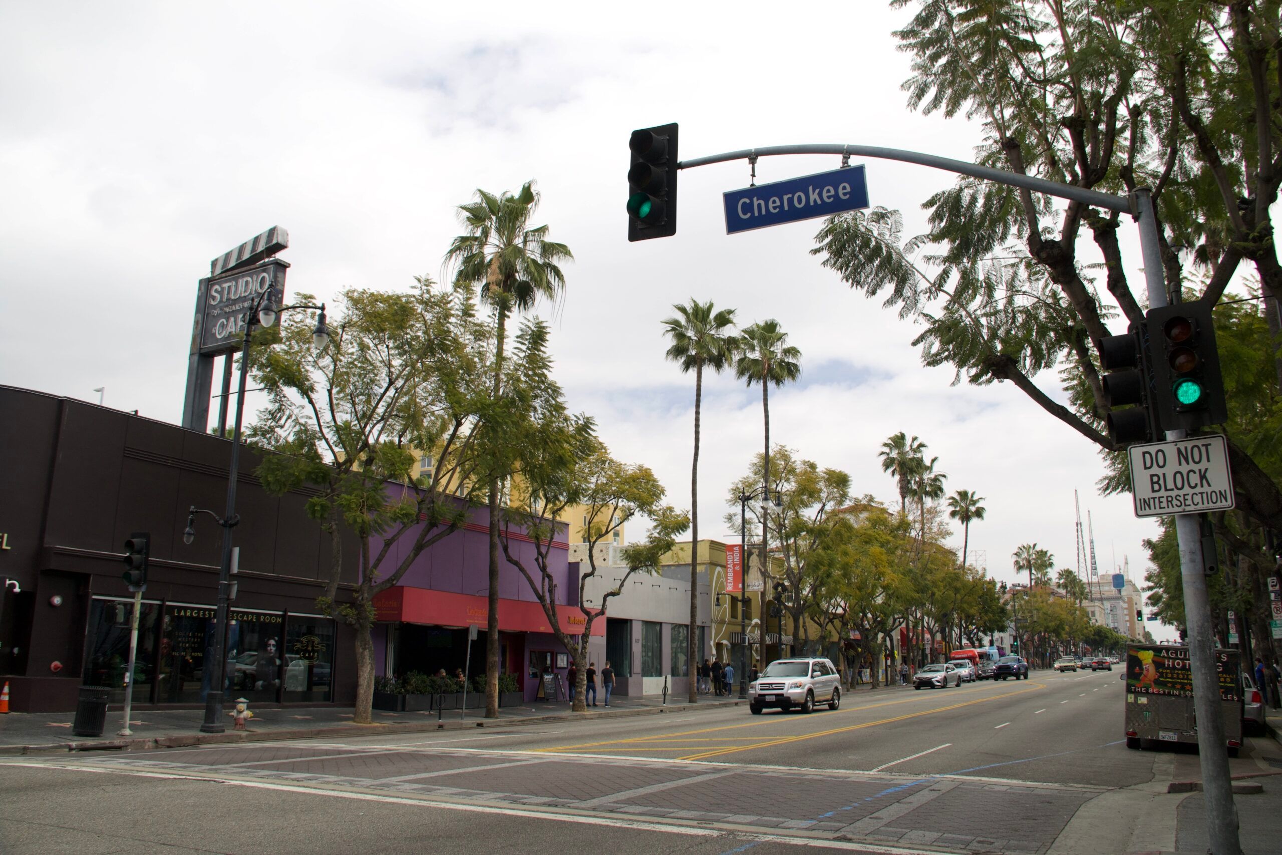 Ulica cherokee w los angeles z palmami, ruchem ulicznym i szyldem studio city