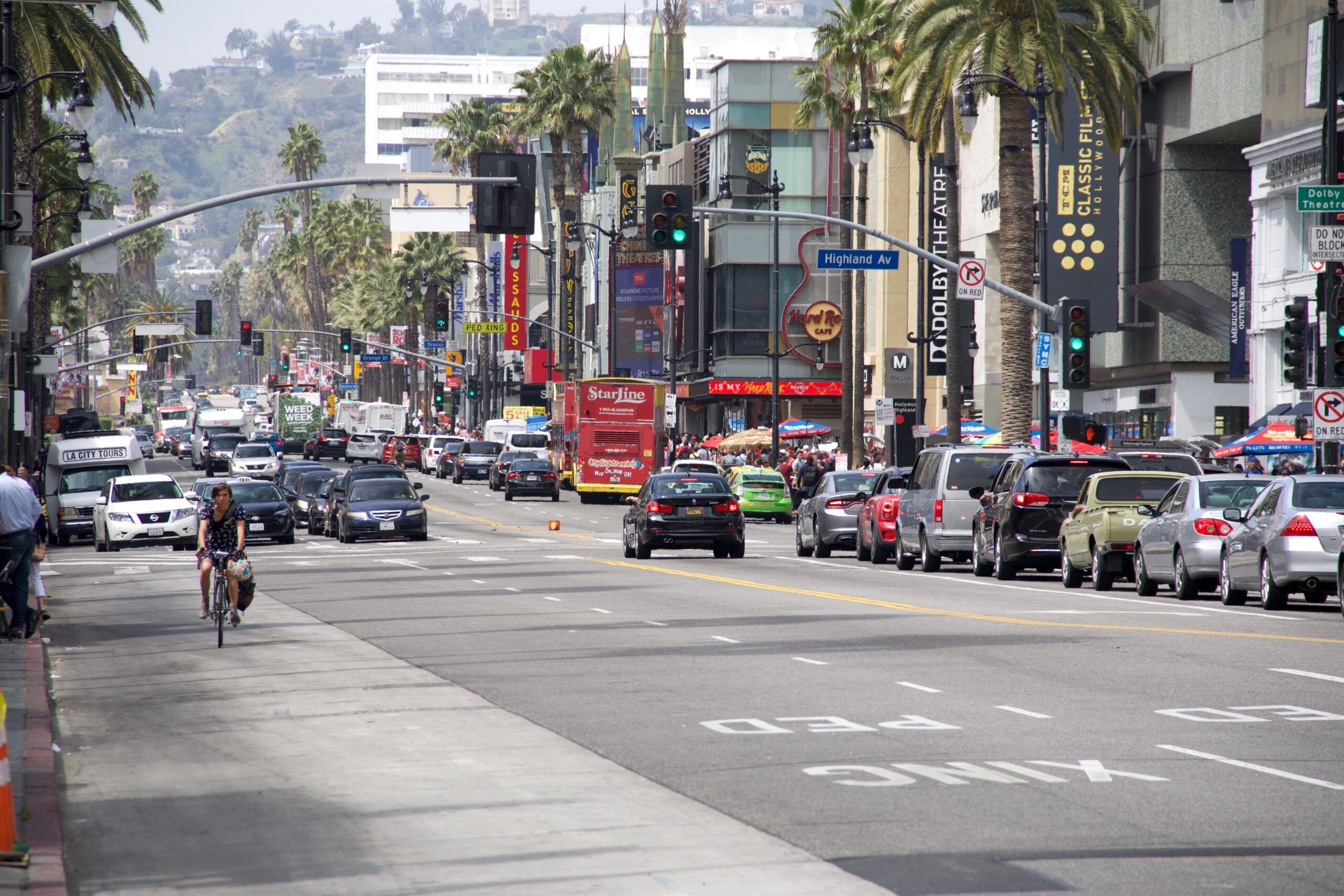 Ulica hollywood boulevard w los angeles z ruchem ulicznym i palmami