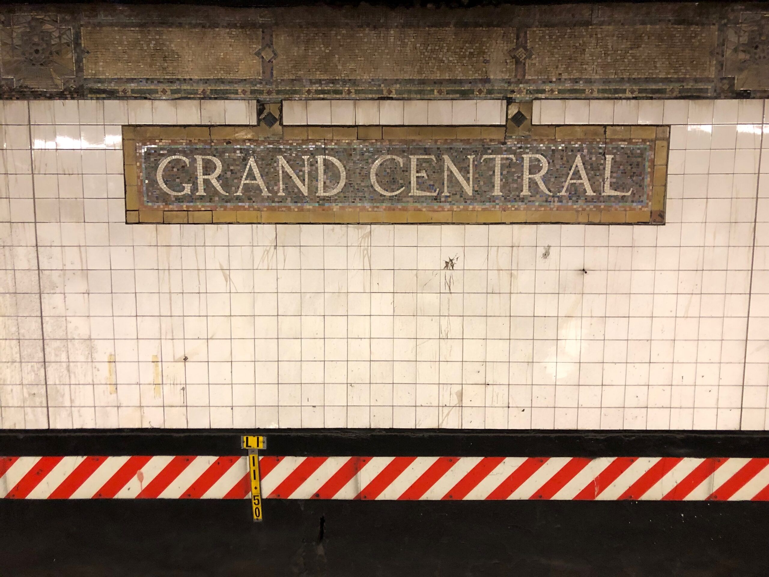 Mozaikowy napis „grand central” na ścianie stacji metra w nowym jorku