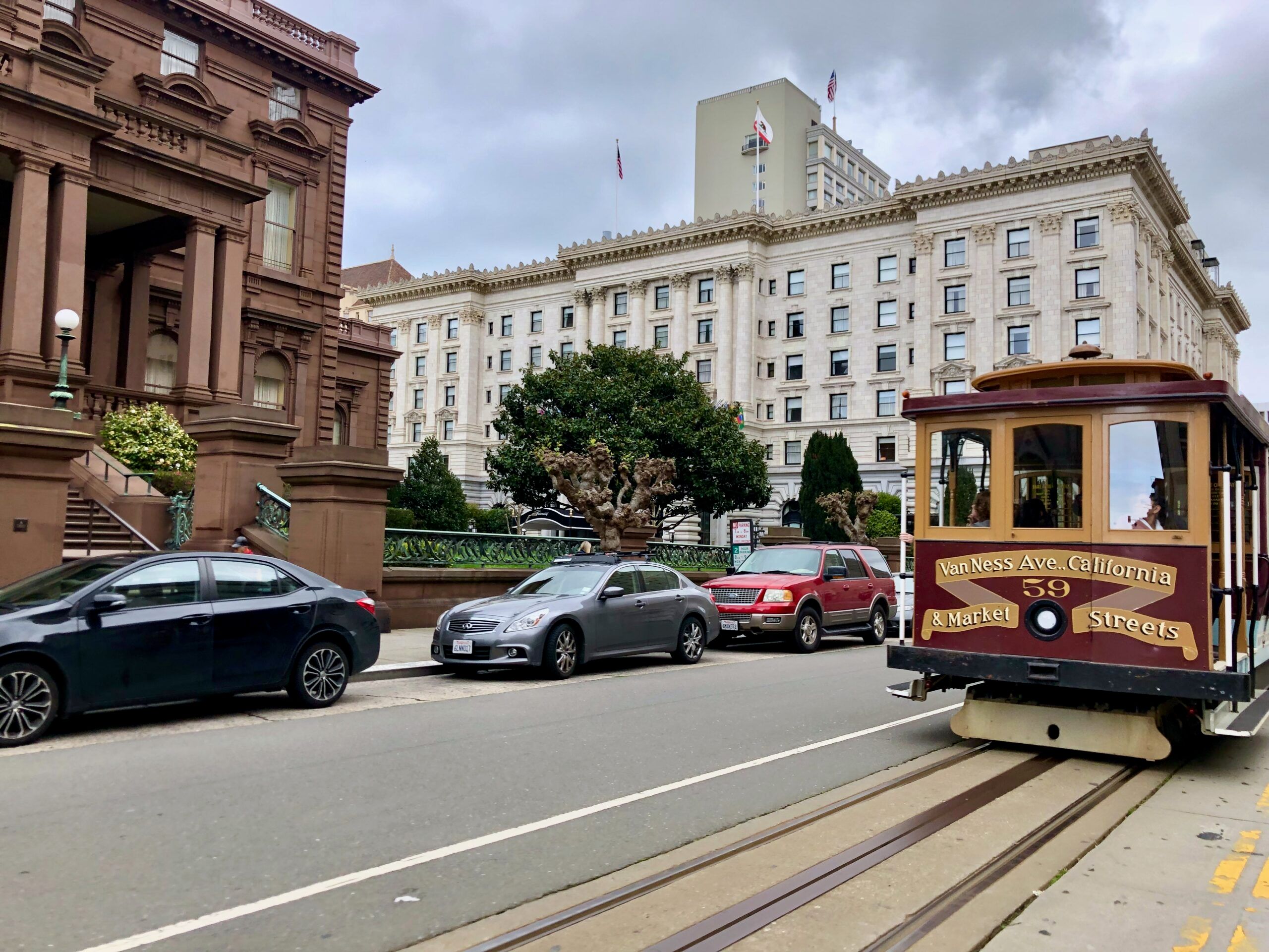 San francisco: zabytkowy tramwaj, budynki i zaparkowane auta przy van ness ave.