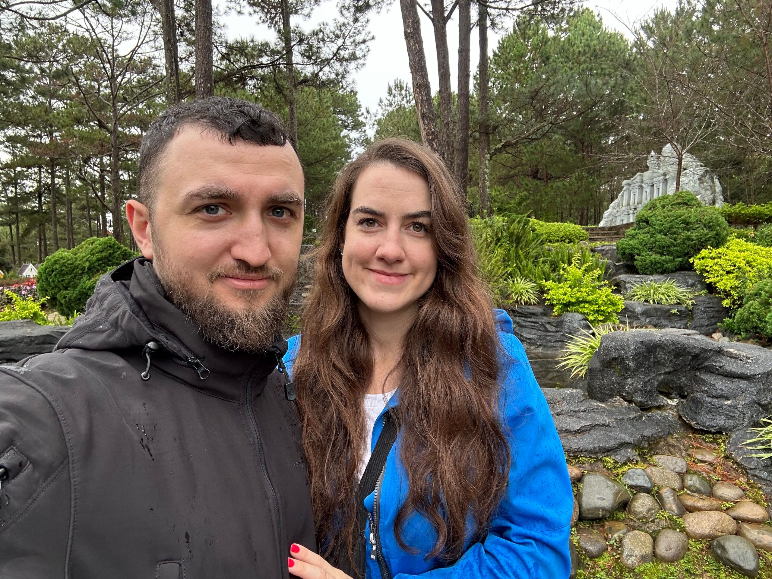 Para w da lat love valley wśród drzew i skał, robiąca selfie.