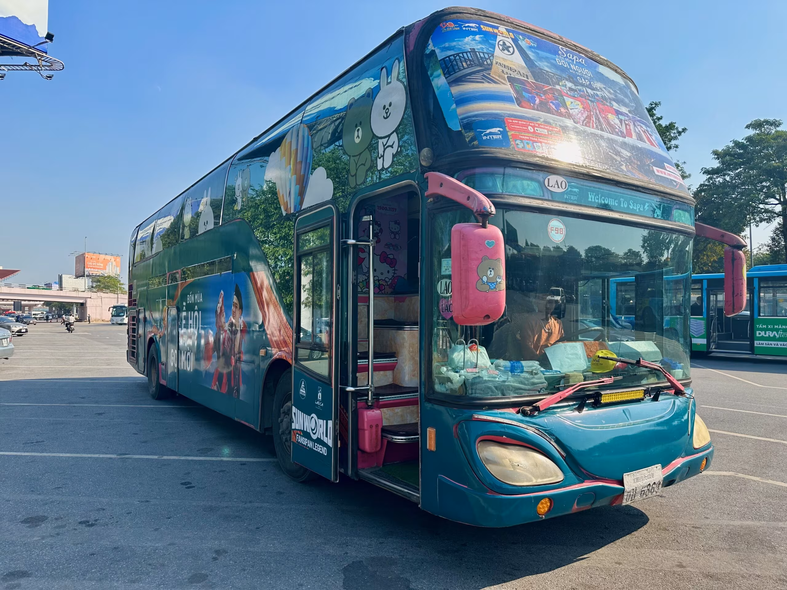 Kolorowy autobus turystyczny w hanoi z motywem postaci z kreskówek i napisem „welcome to sapa”