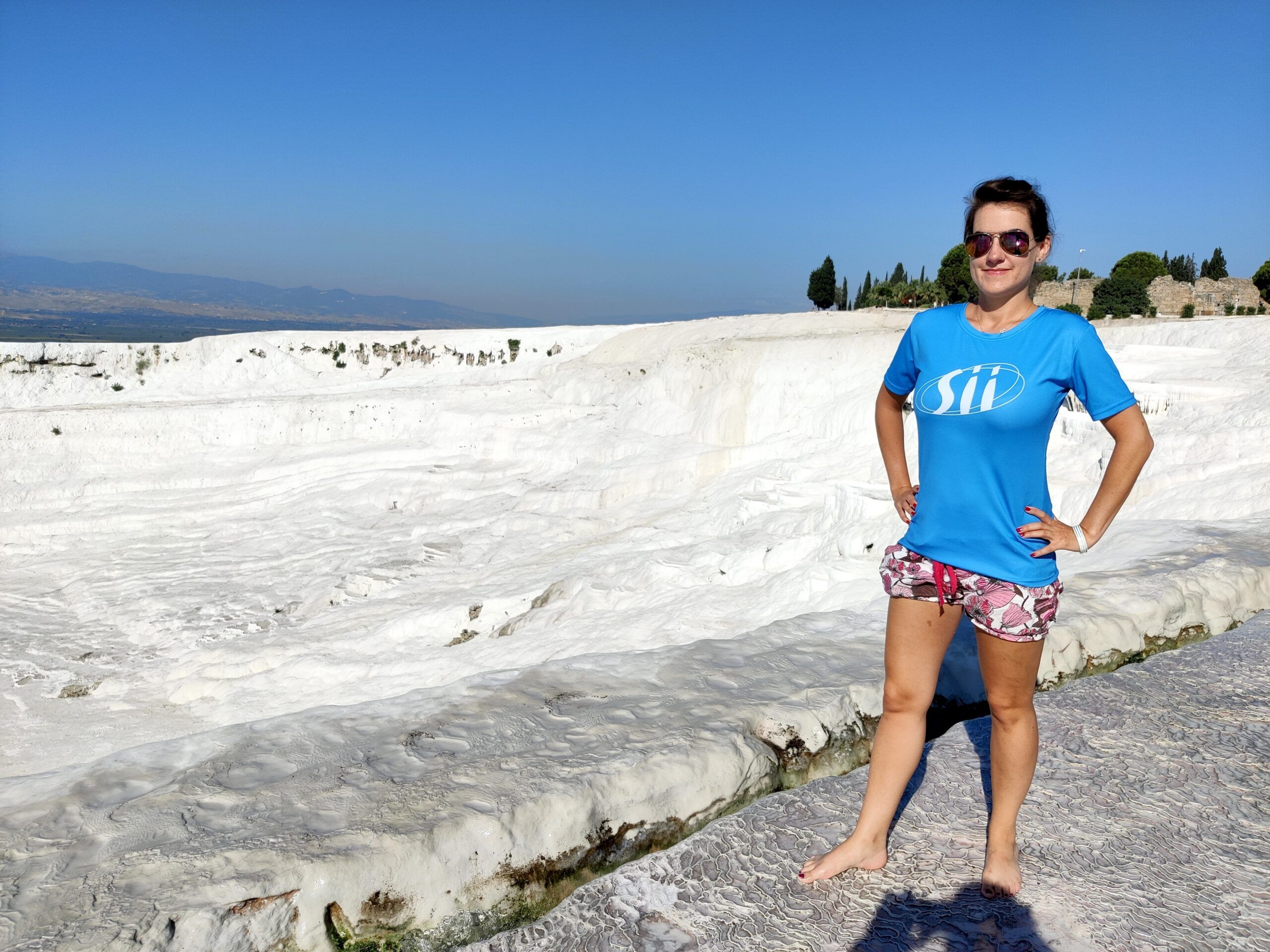 Kobieta stoi na trawertynach pamukkale w turcji.