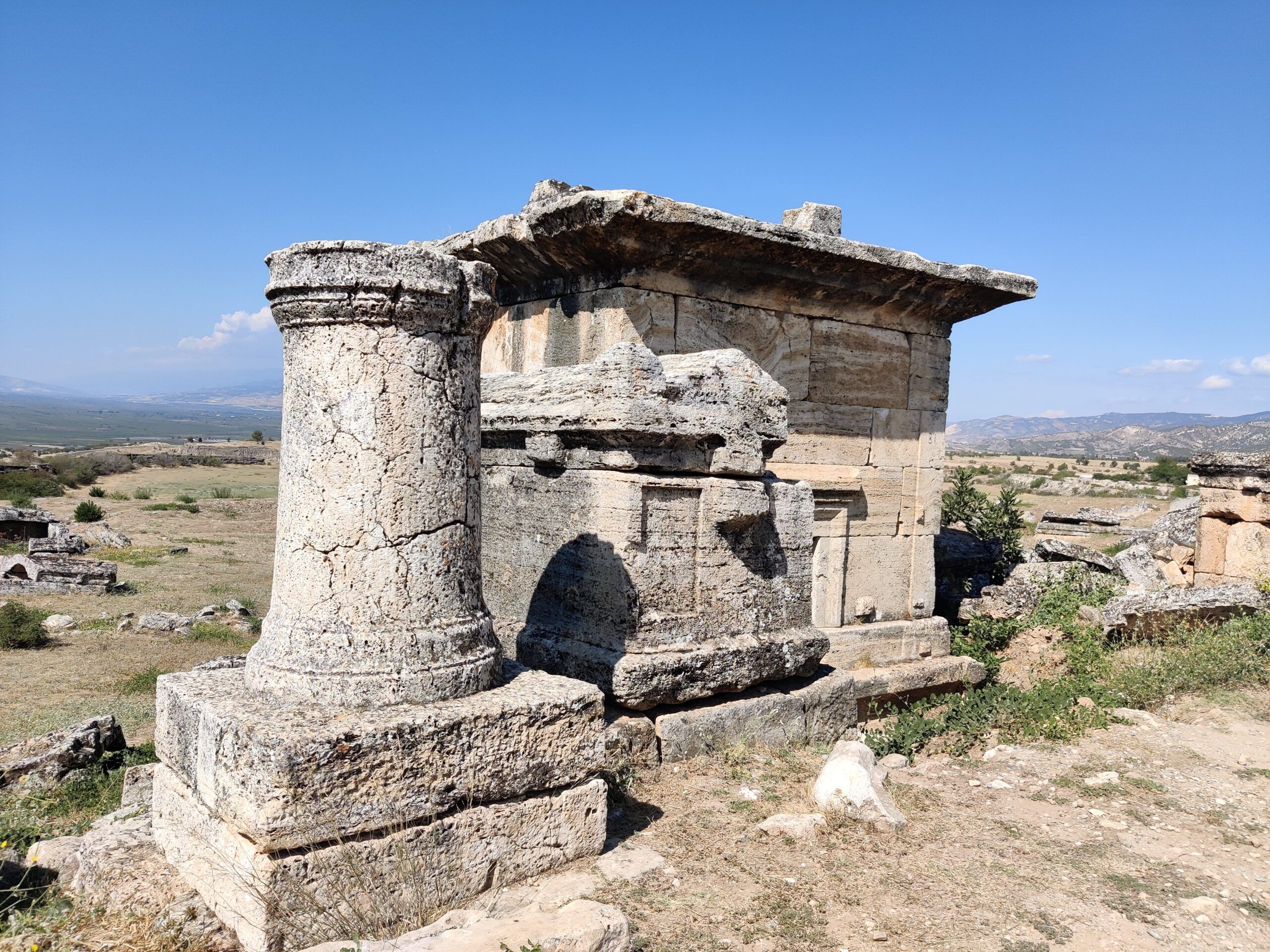 Nekropolia hierapolis w pamukkale, starożytny kamienny grobowiec na tle wzgórz.
