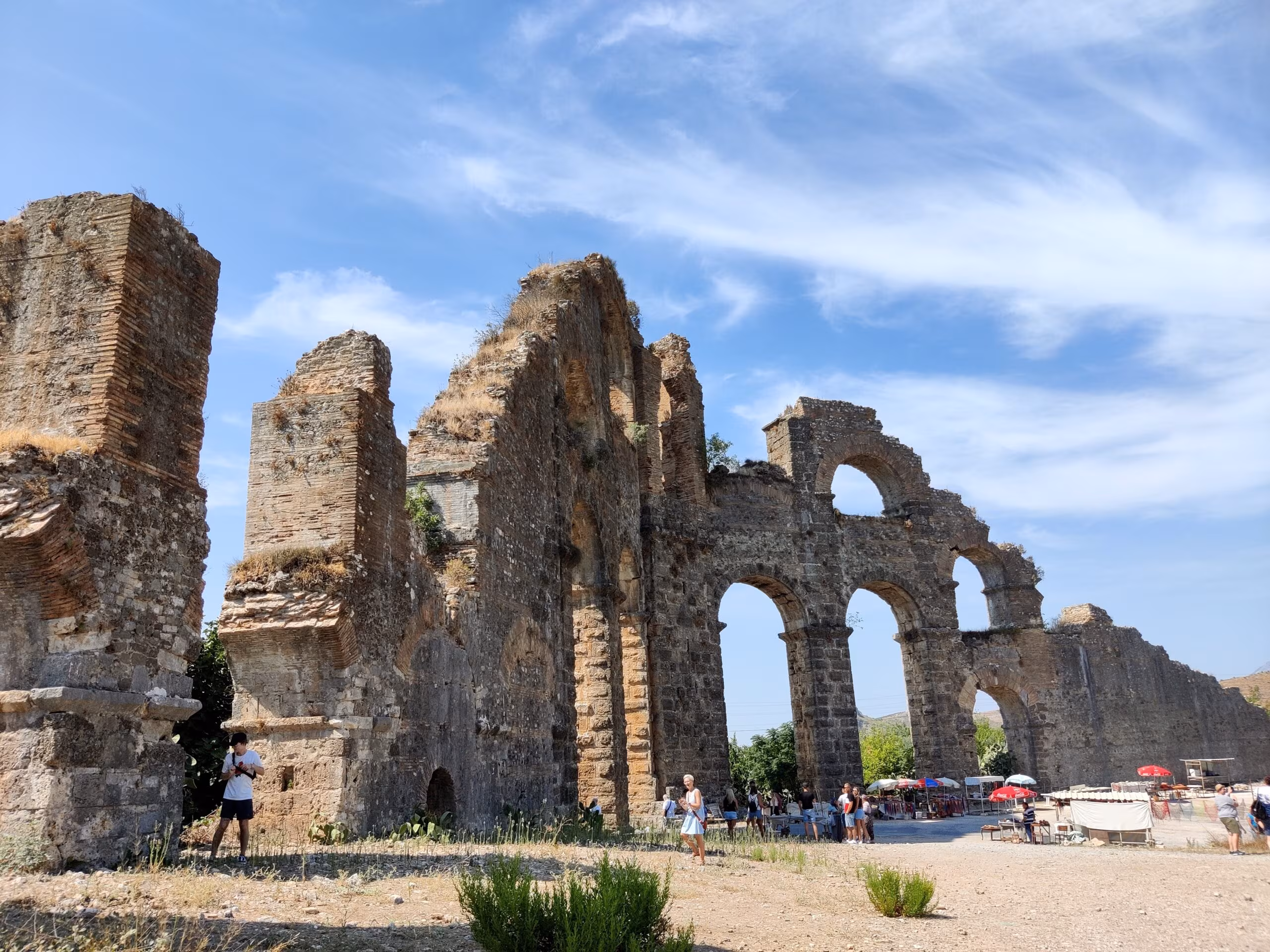 Akwedukt aspendos na riwierze tureckiej w turcji, ruiny z łukami i turystami.