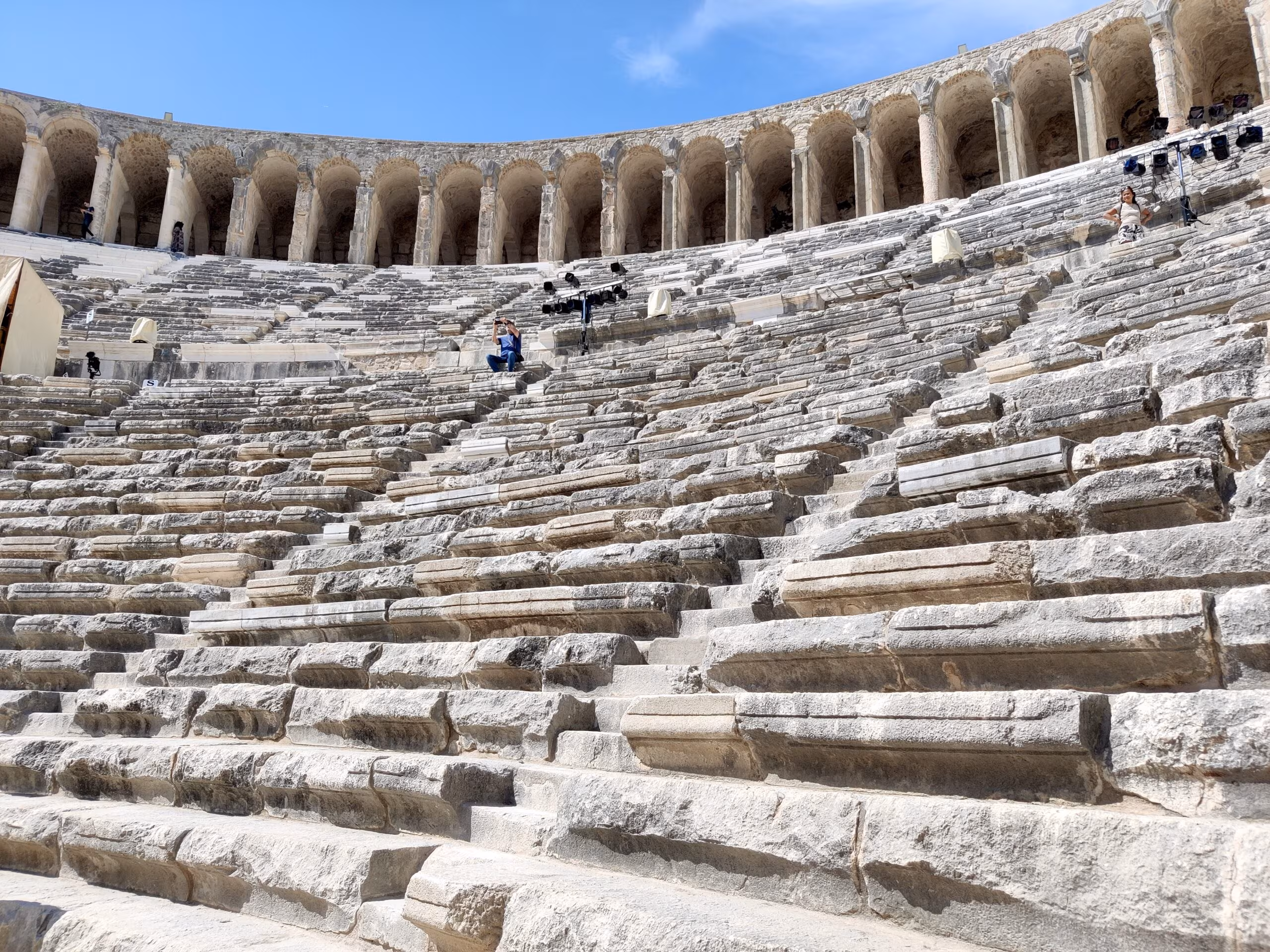 Amfiteatr aspendos w turcji z kamiennymi rzędami siedzeń i arkadami pod błękitnym niebem