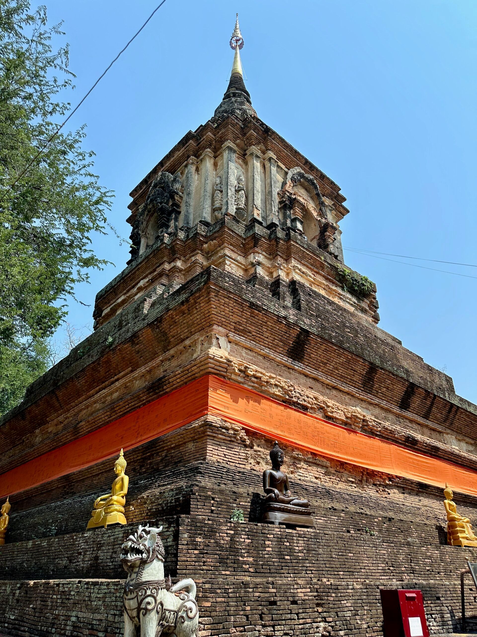 Wat lok moli w chiang mai z ceglaną stupą i złotymi posągami buddy