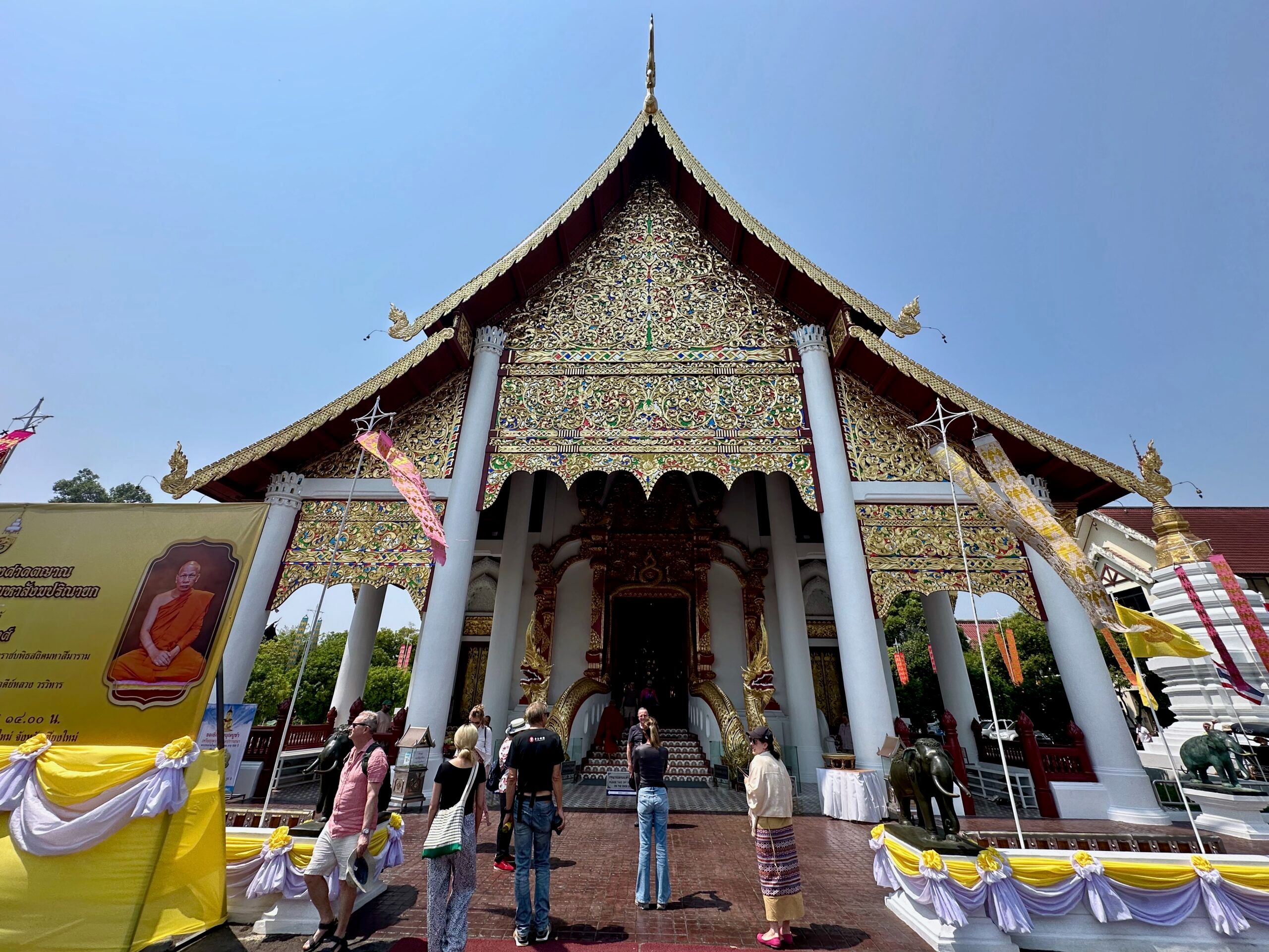 Watchediluang varaviharn w chiang mai, ozdobiona świątynia buddyjska z turystami na dziedzińcu