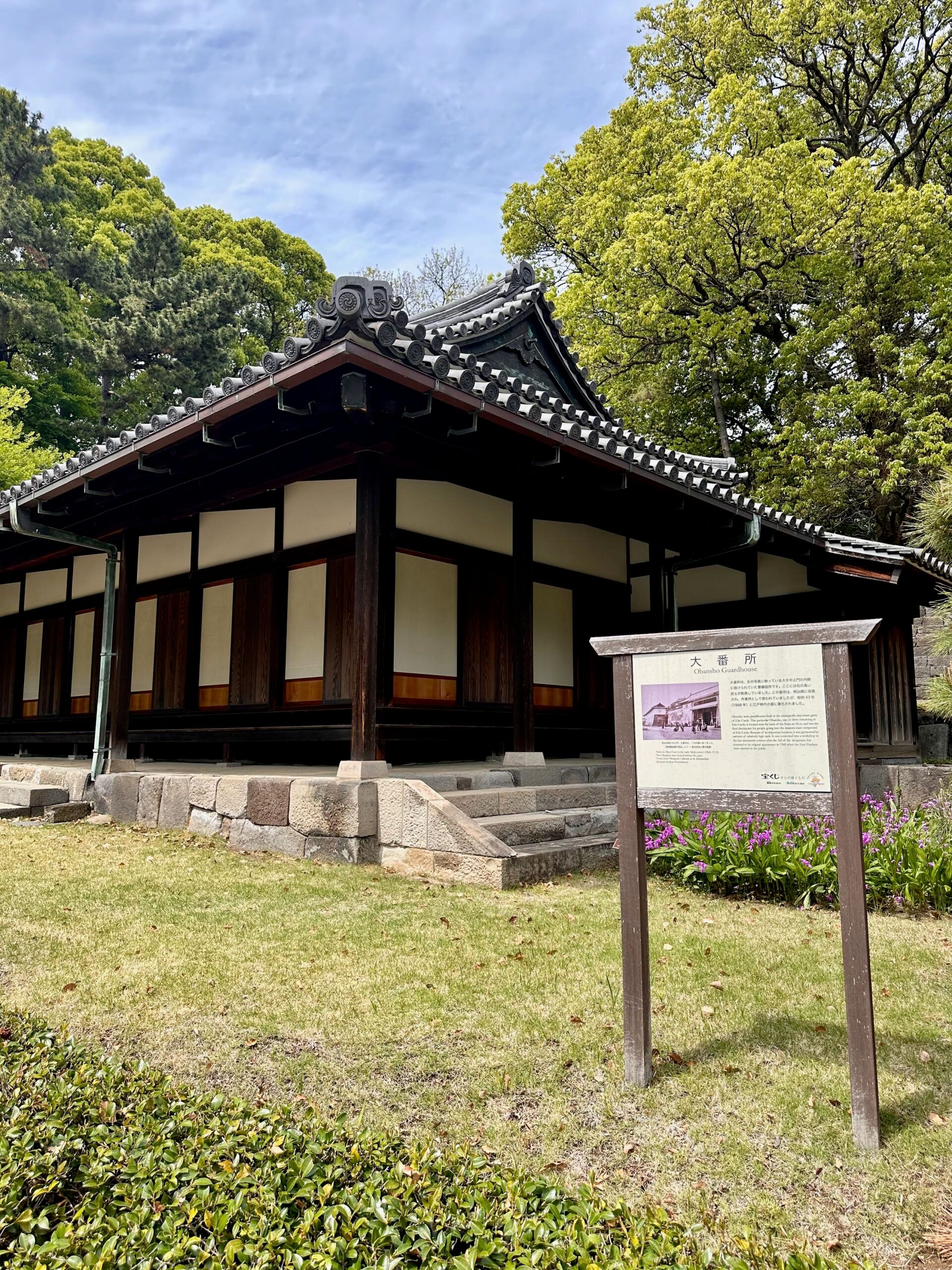 Chidorigafuchi w tokio: tradycyjny japoński budynek z tablicą informacyjną wśród drzew