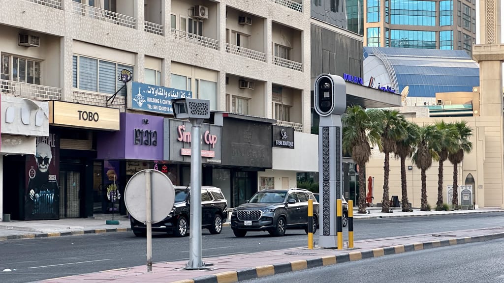 Radar w kuwait city z ulicą, palmami i niską zabudową handlową