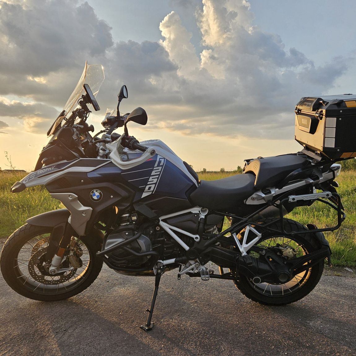 Motocykl turystyczny bmw gs trophy na wiejskiej drodze w niemczech o zachodzie słońca