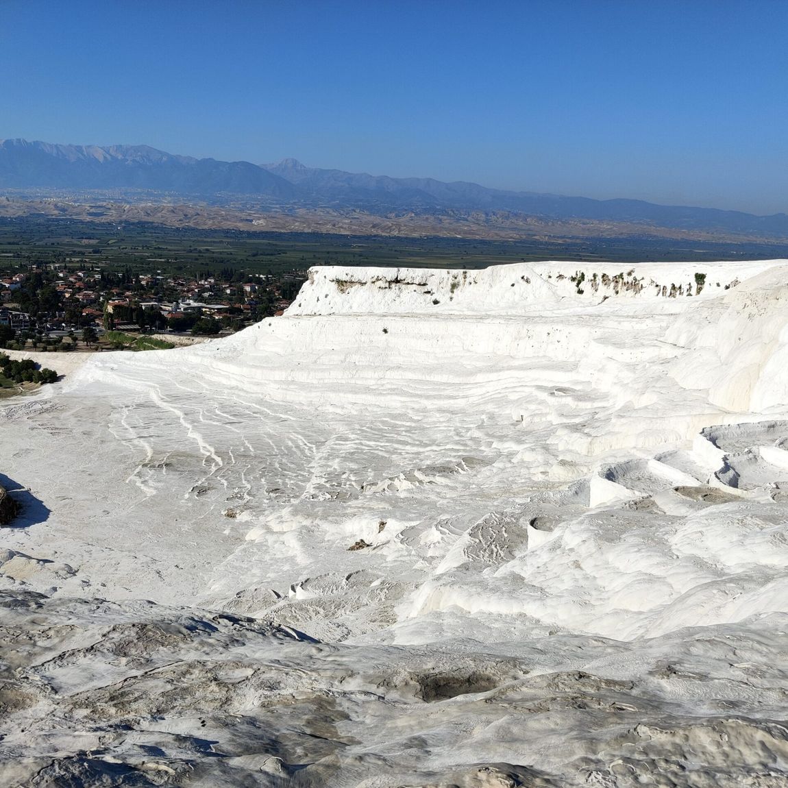 Tarasy wapienne pamukkale z widokiem na dolinę i góry w tle
