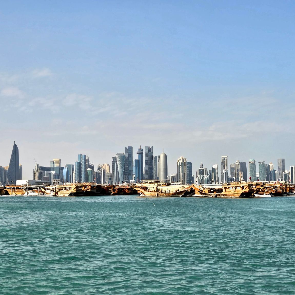Doha corniche w katarze z panoramą miasta i łodziami na wodzie