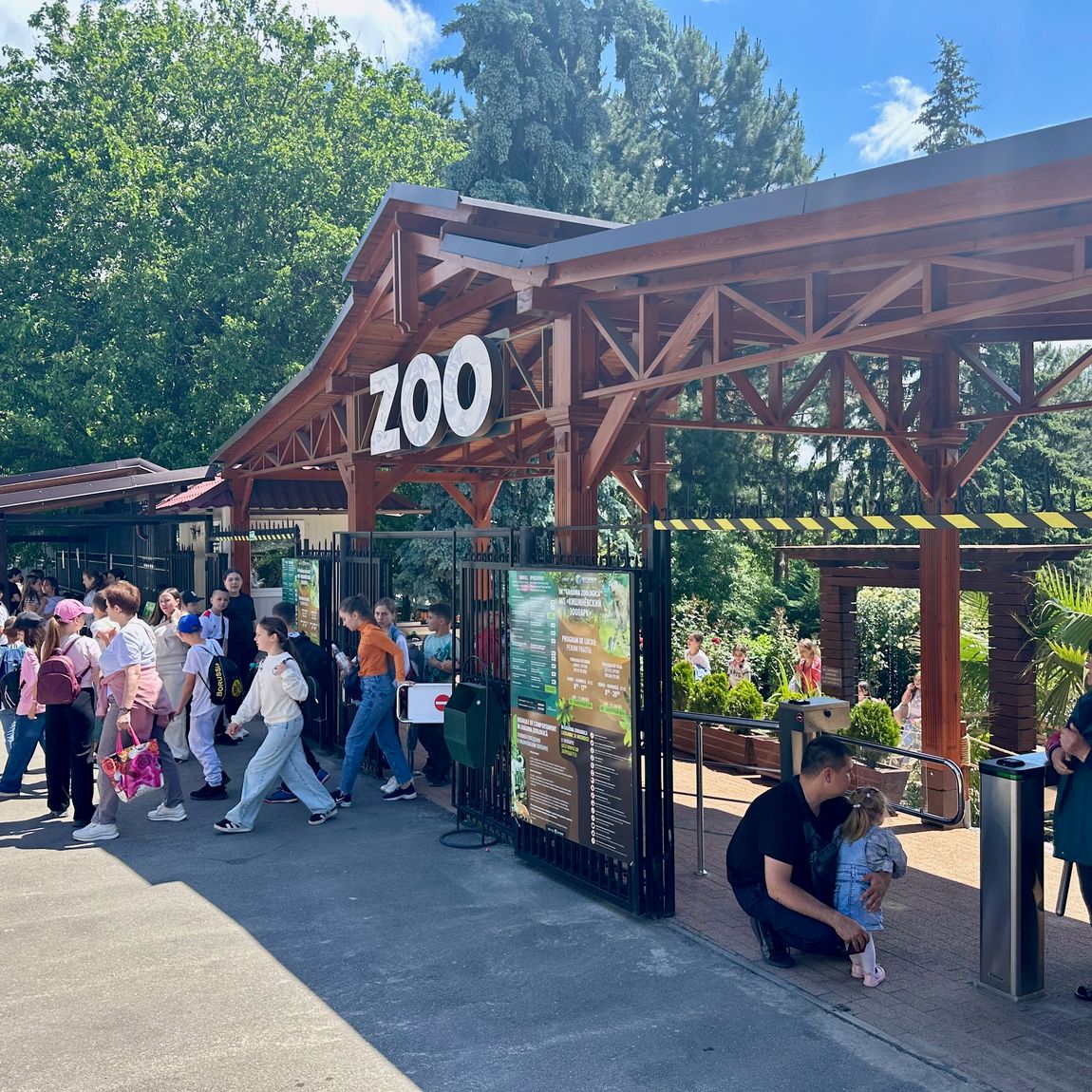 Wejście do chișinău zoo z tłumem odwiedzających przed kasą i bramką wejściową.
