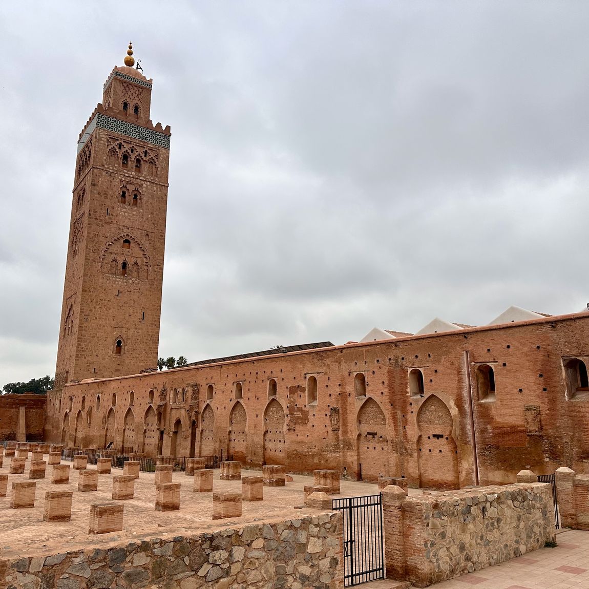 Marrakech koutoubia mosque in morocco, showing the tall minaret and surrounding courtyard walls