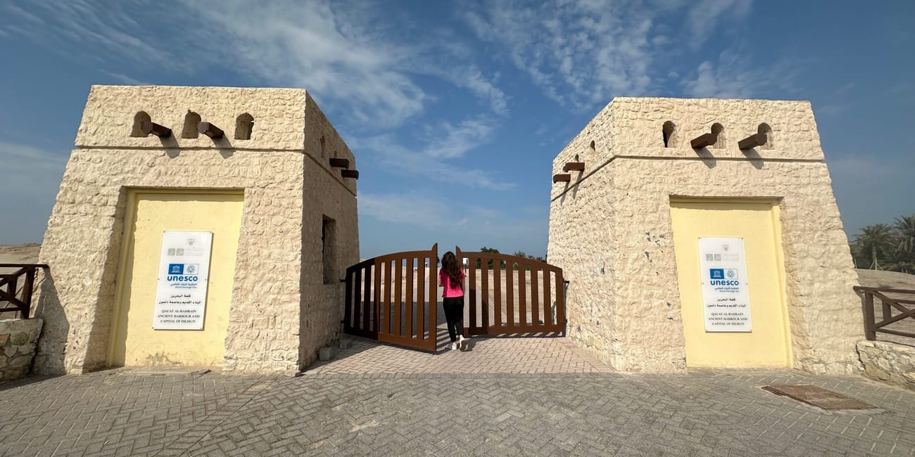 Brama do stanowiska unesco w bahrajnie, z dwiema kamiennymi wieżyczkami i zamkniętą furtą