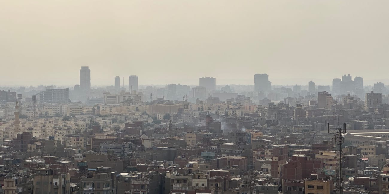 Hazy cairo skyline under a pale, dusty sky