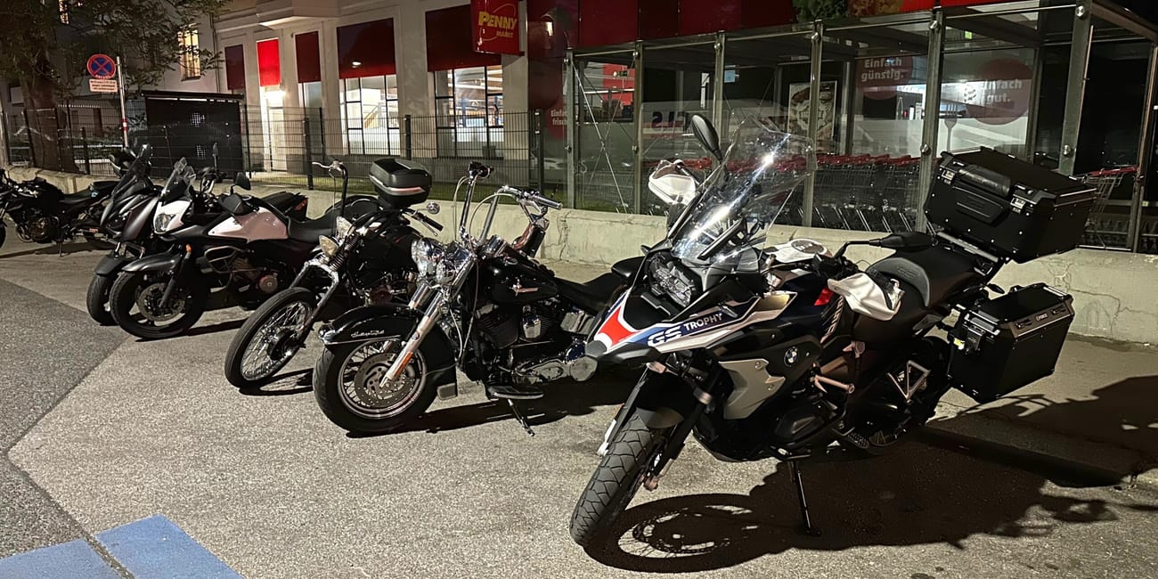 Motocykle zaparkowane nocą przed sklepem penny w wiedniu.