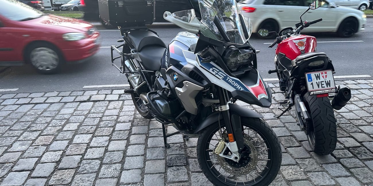 Bmw gs trophy zaparkowany przy ulicy w wiedniu, obok drugiego motocykla.