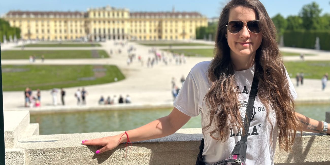 Kobieta przy gloriette w wiedniu, z pałacem w tle.