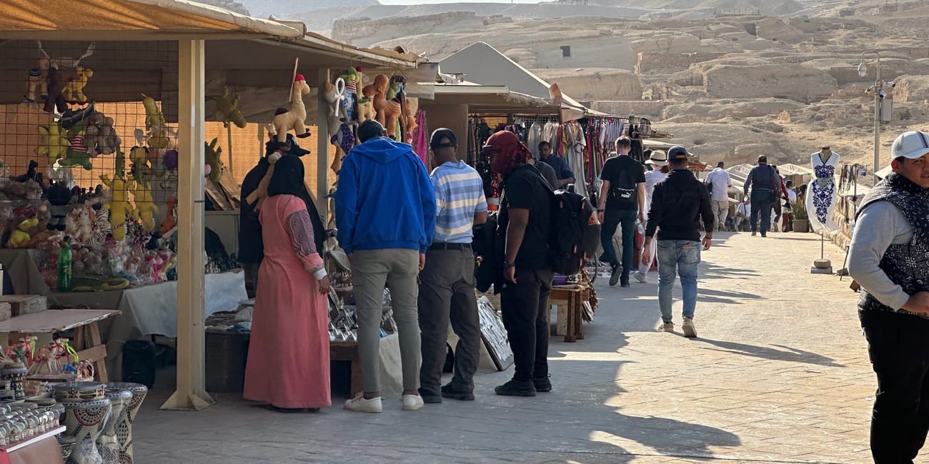 Giza great sphinx z kioskami z pamiątkami i turystami na tle piramidy.