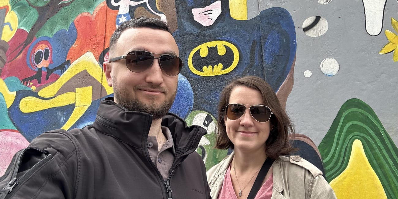 Para na tle kolorowego muralu przy berlinie die berliner mauer.