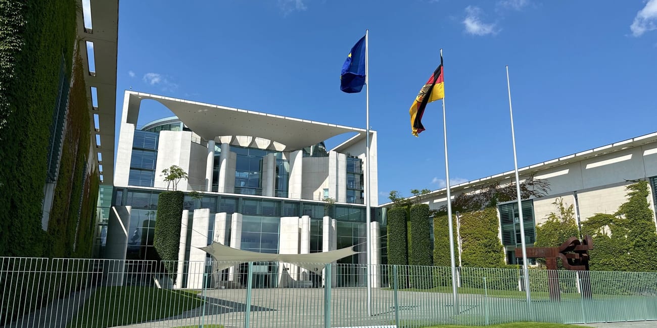 Bundeskanzleramt w berlinie z flagami przed nowoczesnym budynkiem.