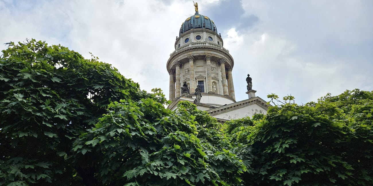 Kopuła katedry w berlinie na tle drzew i nieba na gendarmenmarkt