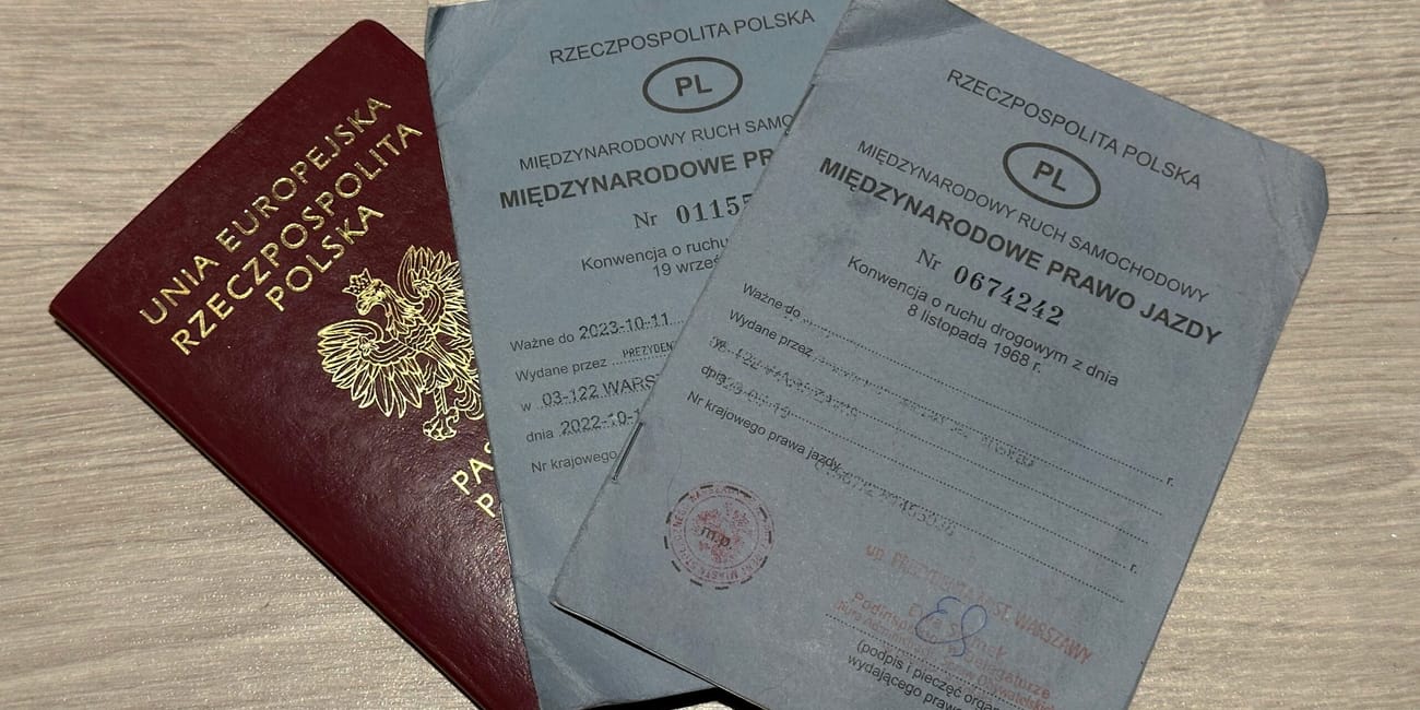 International driving permit article cover showing poland driving document booklets on a wooden surface