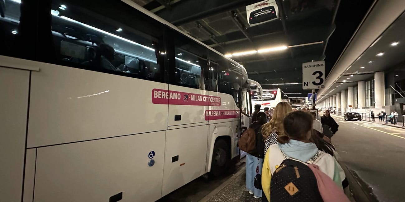 Autokar do centrum mediolanu na stanowisku 3, z pasażerami w kolejce na lotnisku.